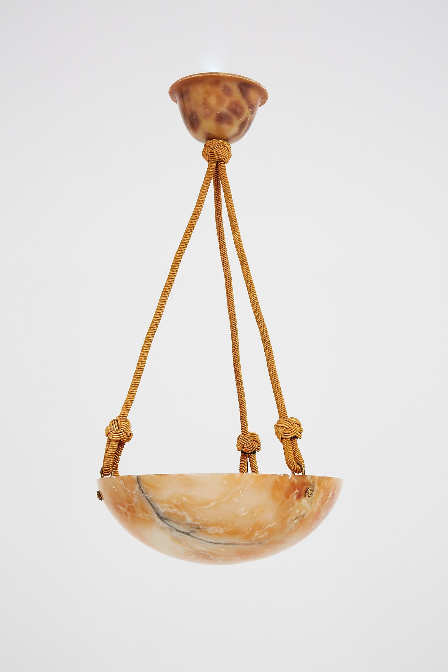 An Art Deco alabaster ceiling light, with its original alabaster ceiling dome and passementerie ropes.
France, circa 1920.
  