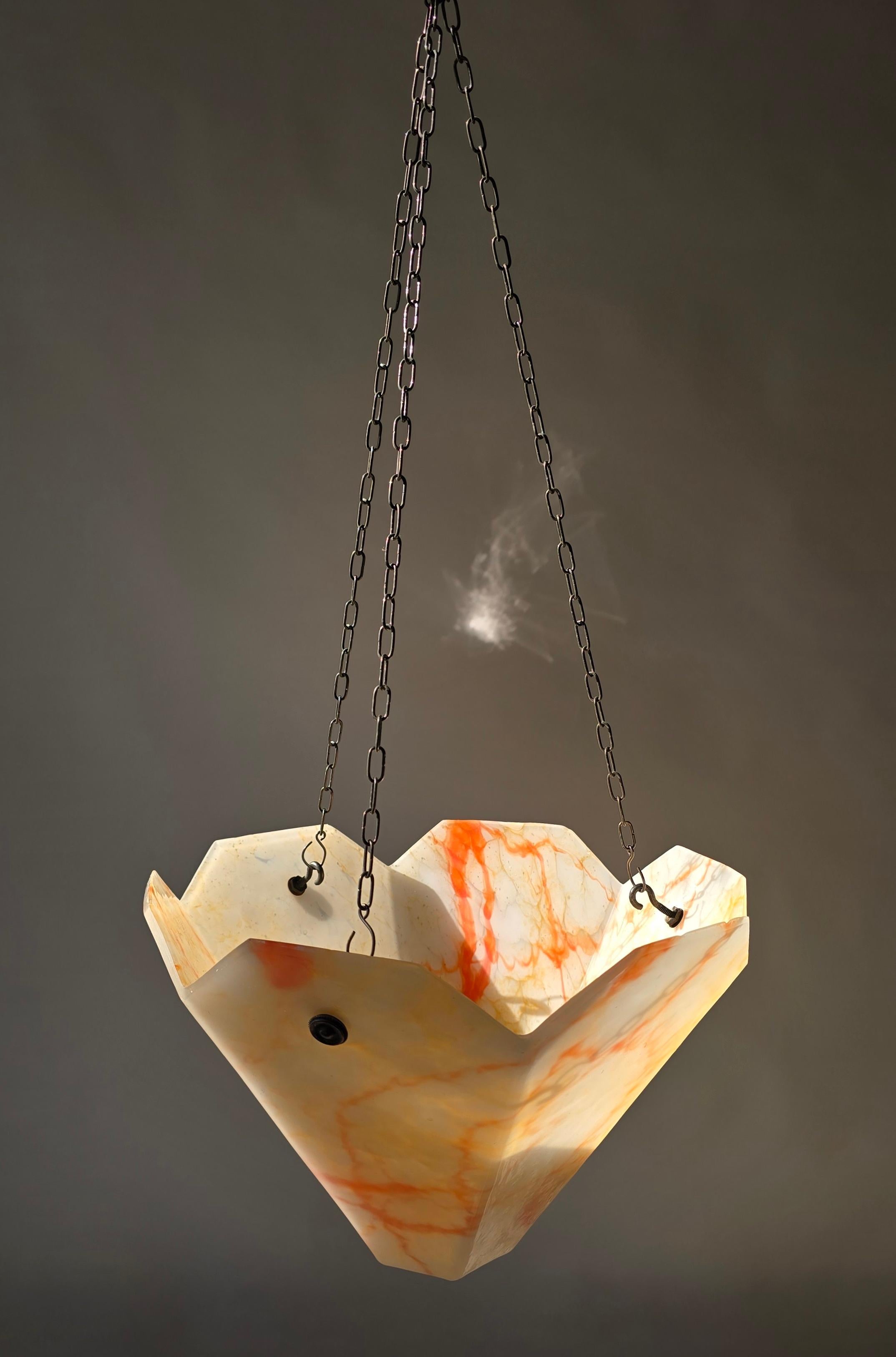 Una straordinaria lampada a sospensione in alabastro Art Deco, Francia, circa anni '30.

La ciotola geometrica sfaccettata è realizzata in alabastro naturale nei toni caldi del crema, del bianco e dell'arancione con una splendida marmorizzazione