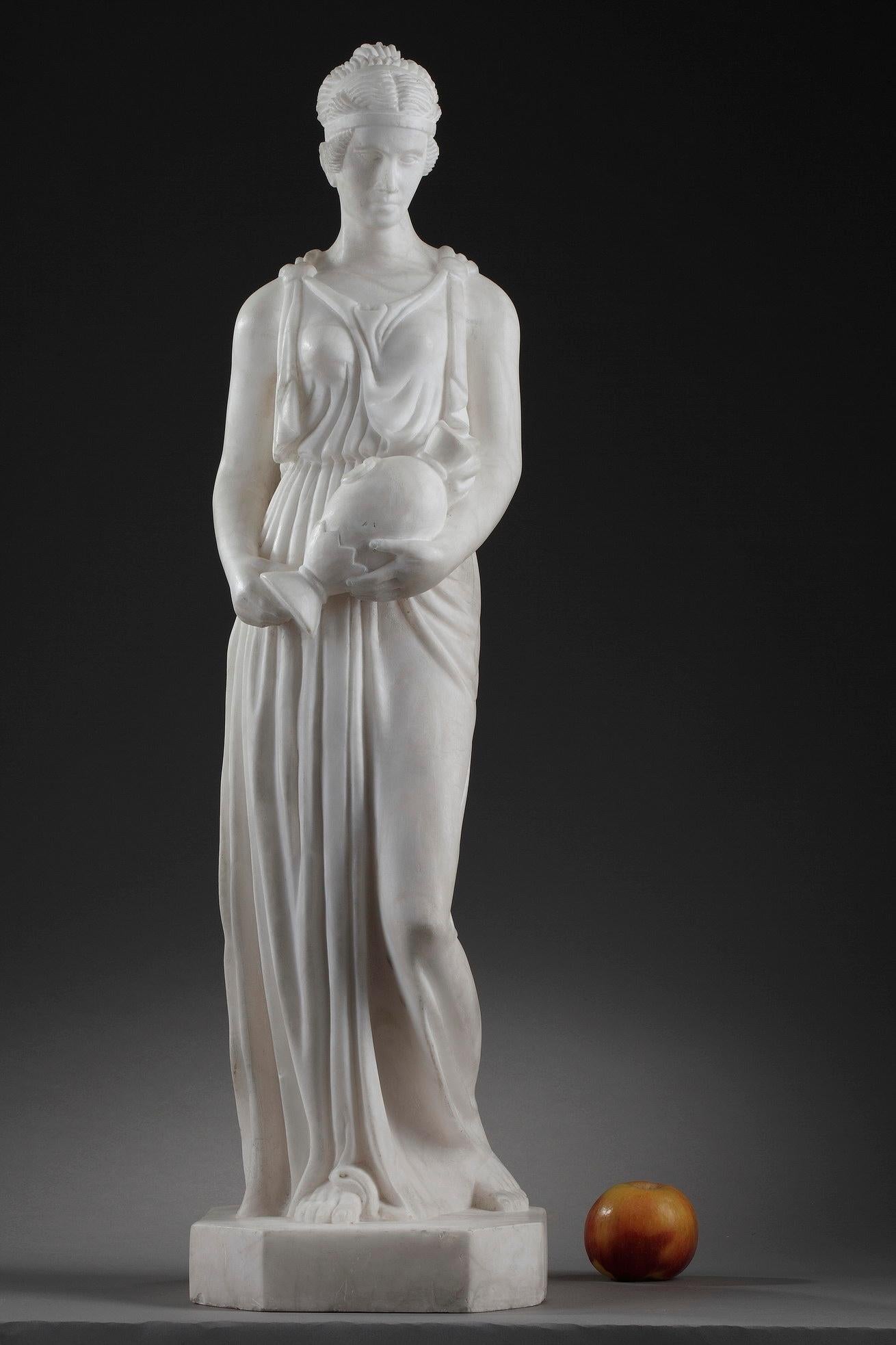 Questa scultura Art Deco raffigura la Samaritana che indossa una tunica drappeggiata sul corpo e porta la brocca. I capelli raccolti in uno chignon sono sostenuti da un diadema. Scolpita in alabastro, la statua è un bellissimo esempio di stile