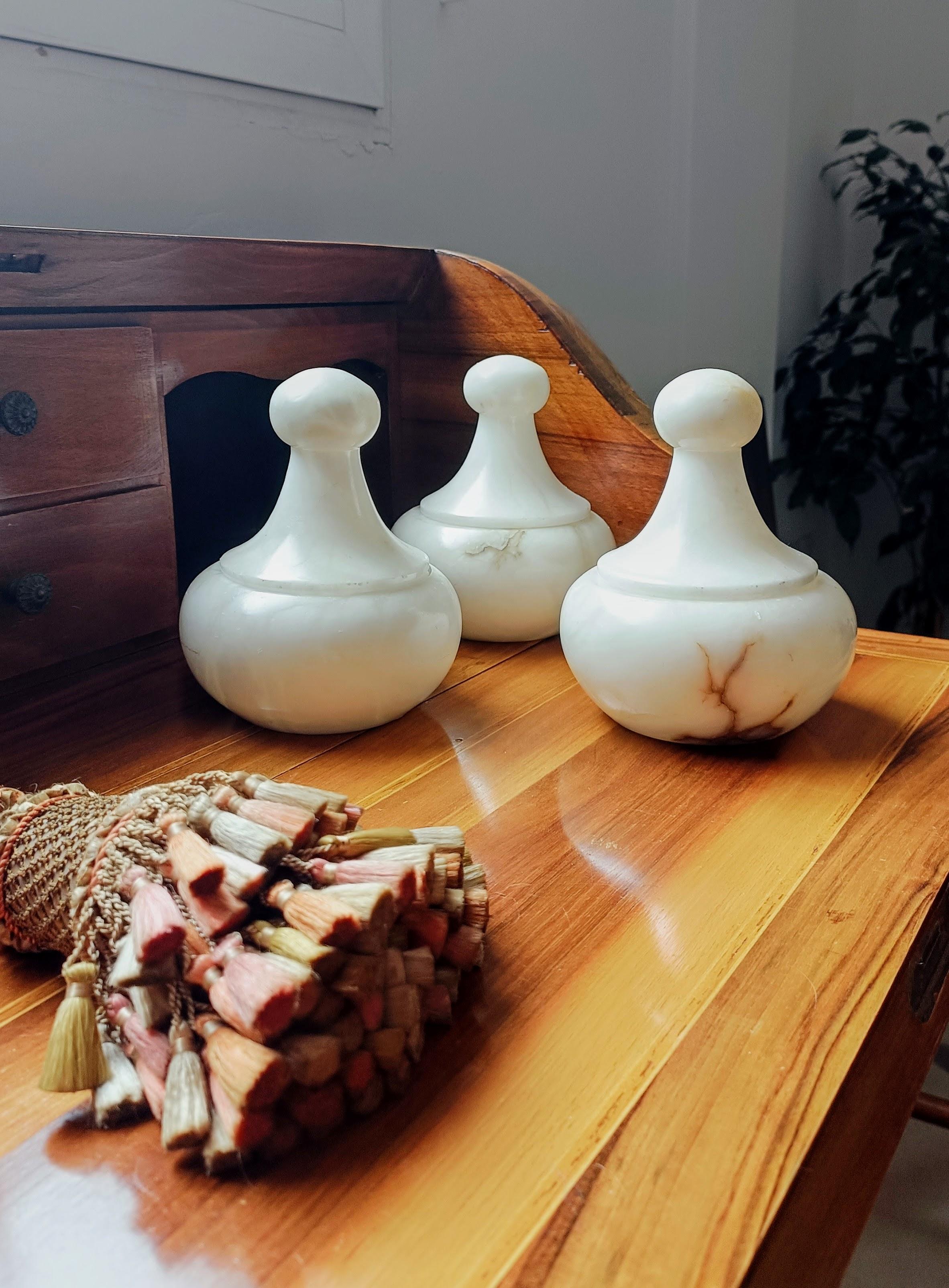 Ein wunderschönes Set aus drei Alabaster-Urnen im Art-Déco-Stil, handgeschnitzt in Spanien um die 1930er Jahre.

In tadellosem Zustand. Alle gleich groß. 

Abmessungen: T. 12cm x H. 15cm (4,72 x 5,90 Zoll)

Schwere, solide Stücke. Atemberaubend in
