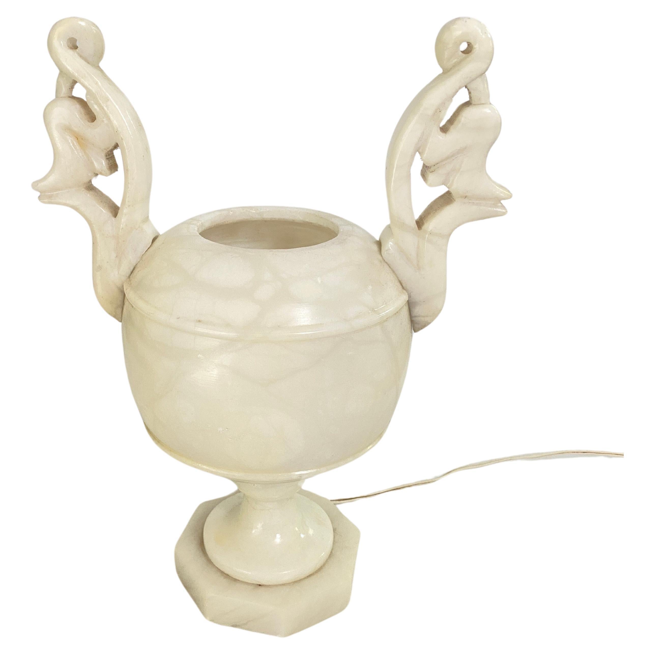 Sculptural alabaster Art Deco period urn table lamp with neoclassical design, France, 1960s.
This elegant carved alabaster neoclassical 'uplighter' urn lamp will be a nice addition placed in a console table or side table.
It provides a charming