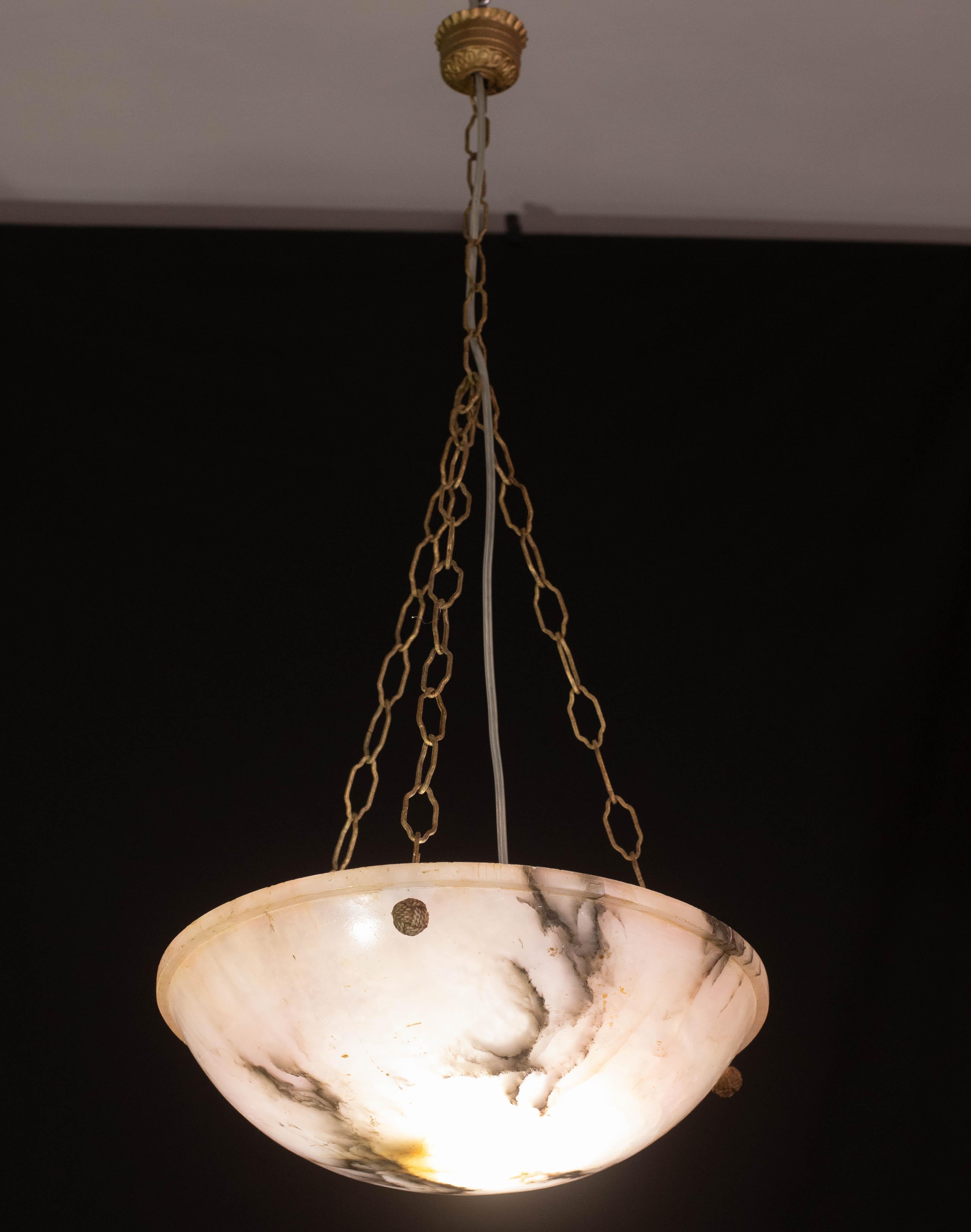 Antigua lámpara colgante de alabastro de estilo Art Déco, hacia la década de 1950.
Una sola pieza de alabastro, bellamente trabajada con matices y reflejos de otros colores cuando se ilumina, suspendida de tres cadenas originales.
La luz que brilla