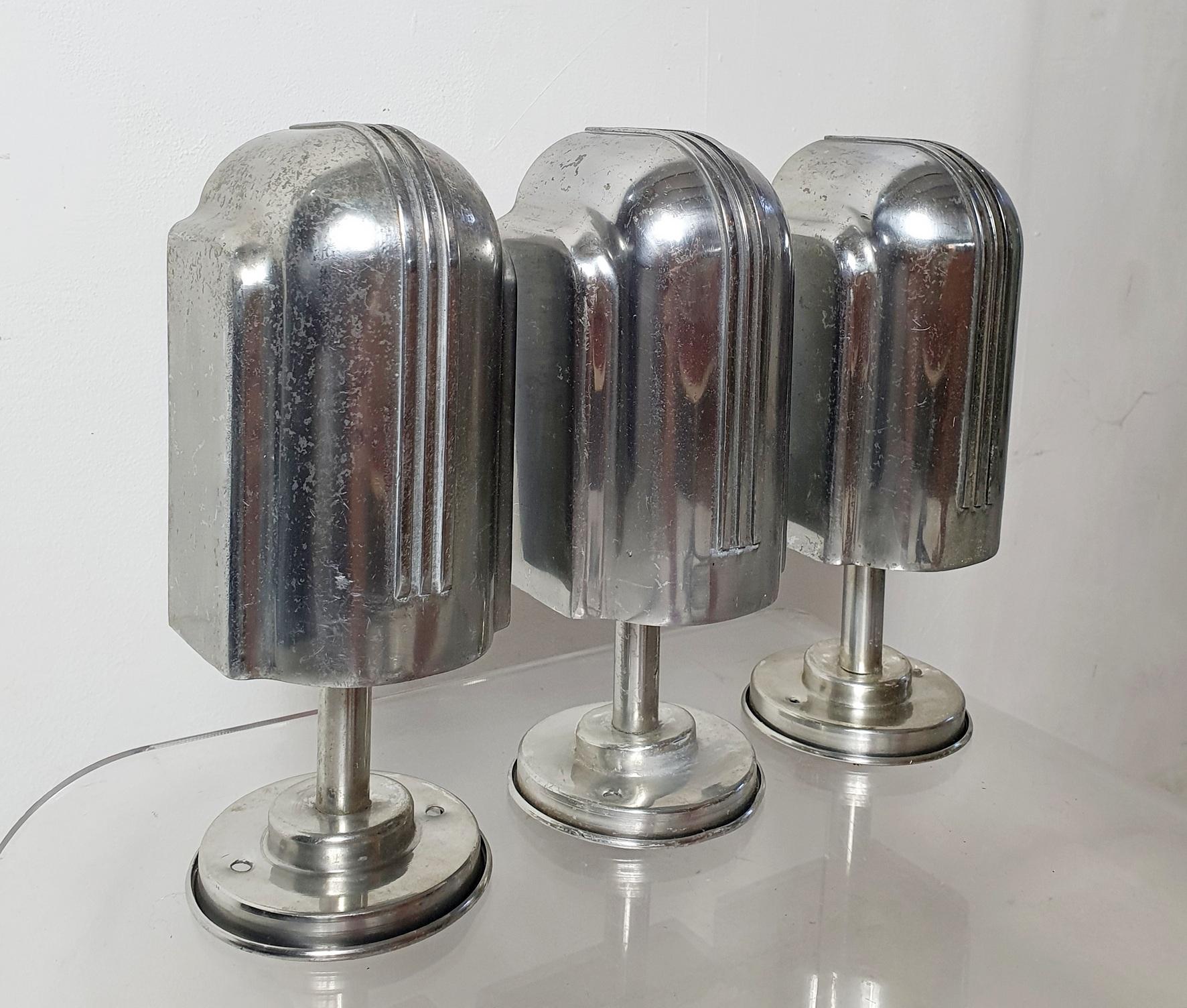 This is a rare set of three original wall sconces from the 1930's produced in italy in cast aluminium. Designed in a typical art deco style exuding elegance. Would work beautifully over the bookcase or as a spotlight. In nice condition with natural