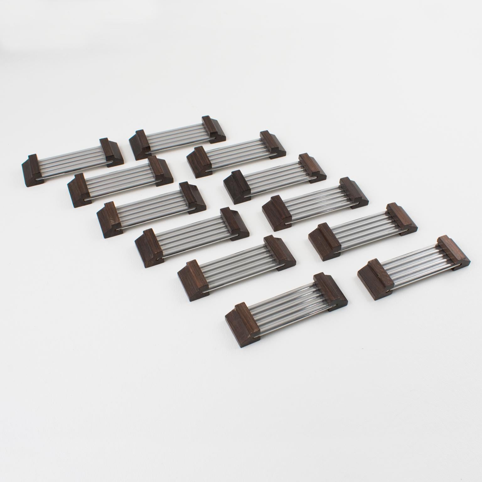 This elegant French Art Deco set of twelve chopsticks or knife rests is made of aluminum and Macassar wood. The modernist shape displays a waved metal flat stick bar and geometric carved wood sides. There is no visible maker's mark, and the set is