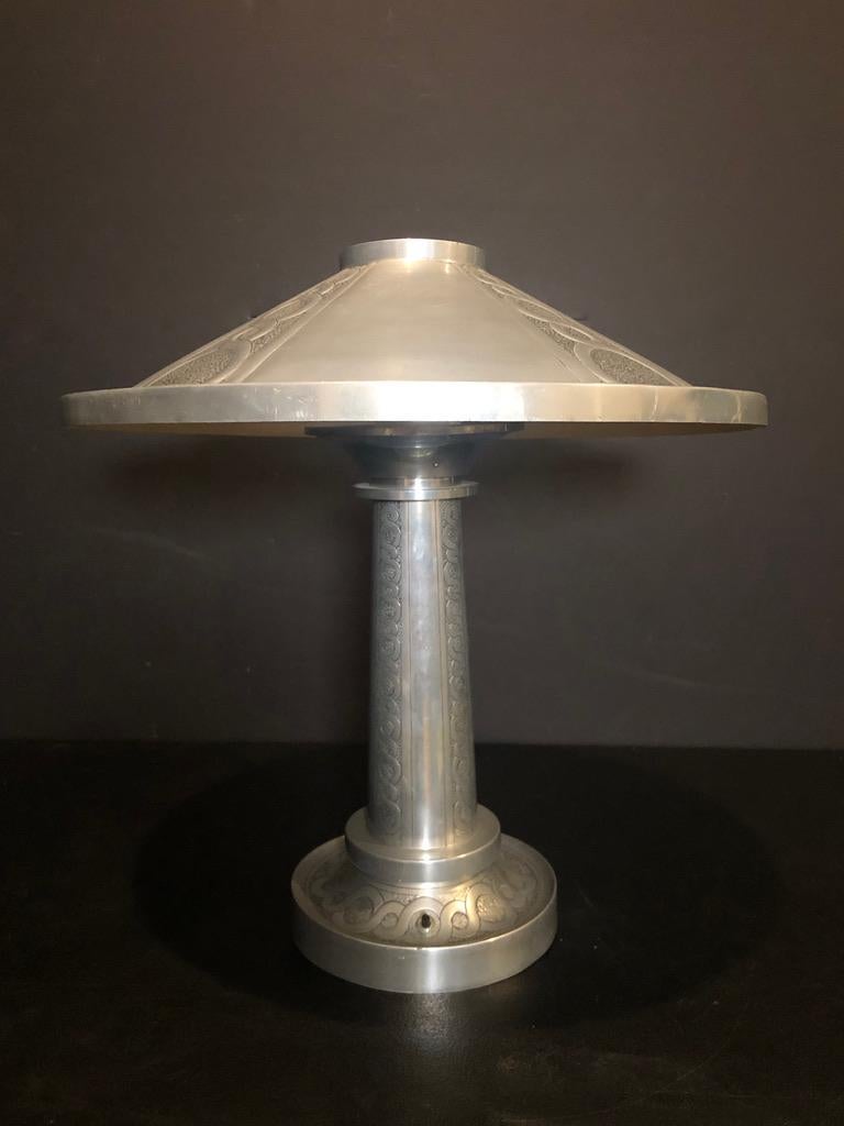 Machine Age/Art Deco embossed aluminum table lamp and shade. Highly stylized. All original lamp base and shade with embossed details. In working condition with more contemporary wiring.