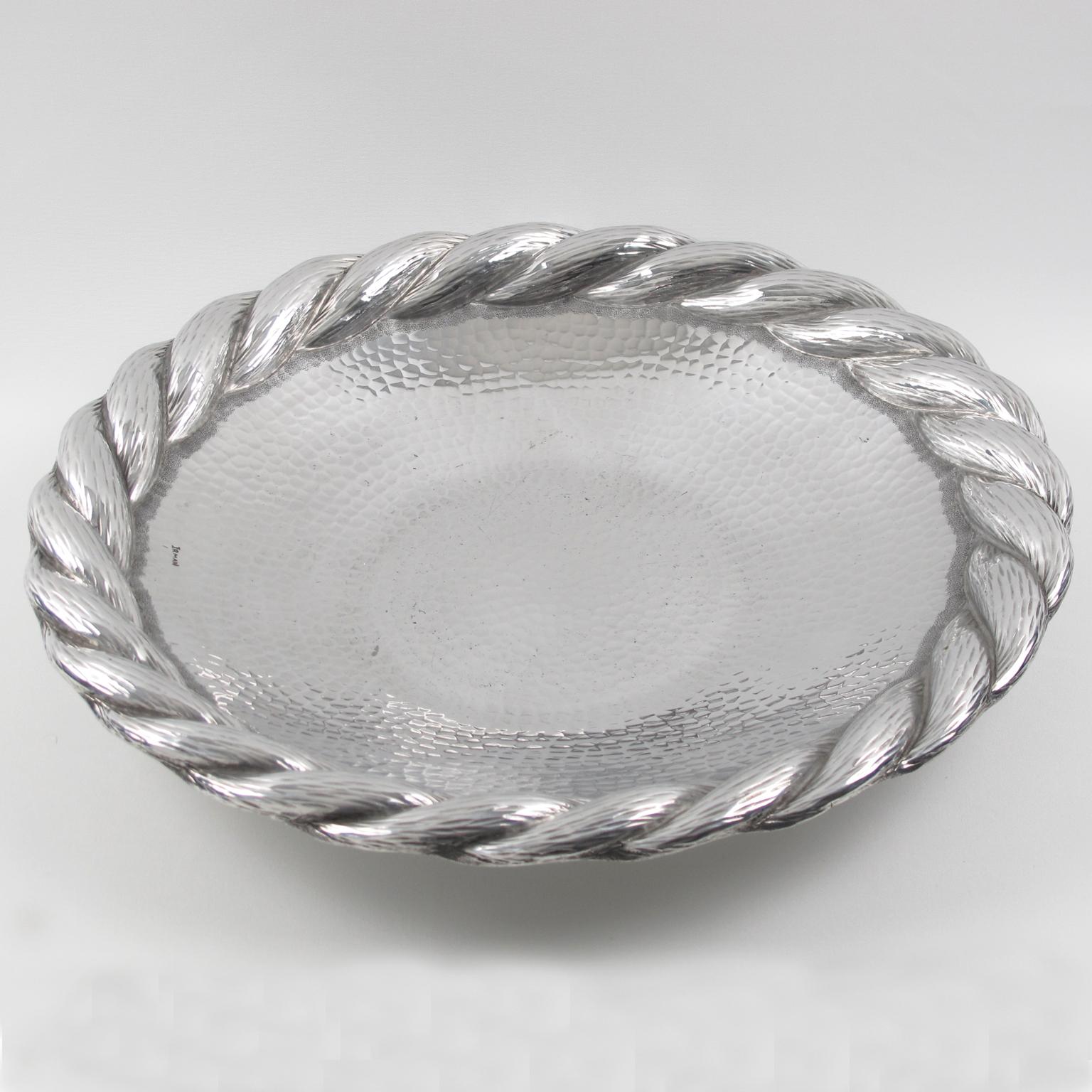 This elegant large platter, serving tray, or centerpiece in polished aluminum was designed and crafted by Irman, France, in the 1930s. This is a perfect barware accessory or decorative centerpiece. The design boasts a hammered textured pattern with