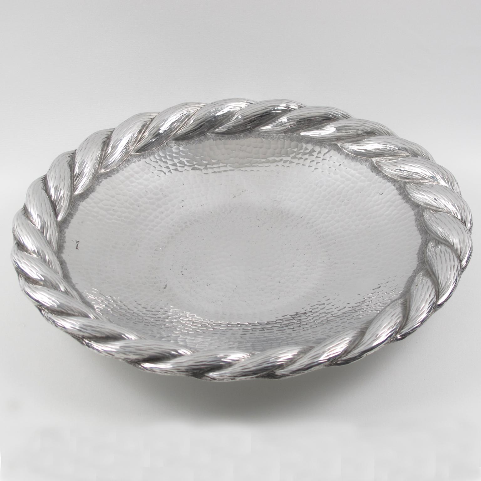 This elegant large platter, serving tray, or centerpiece in polished aluminum was designed and crafted by Irman, France, in the 1930s. It is a perfect barware accessory or decorative centerpiece. The design boasts a hammered textured pattern with a