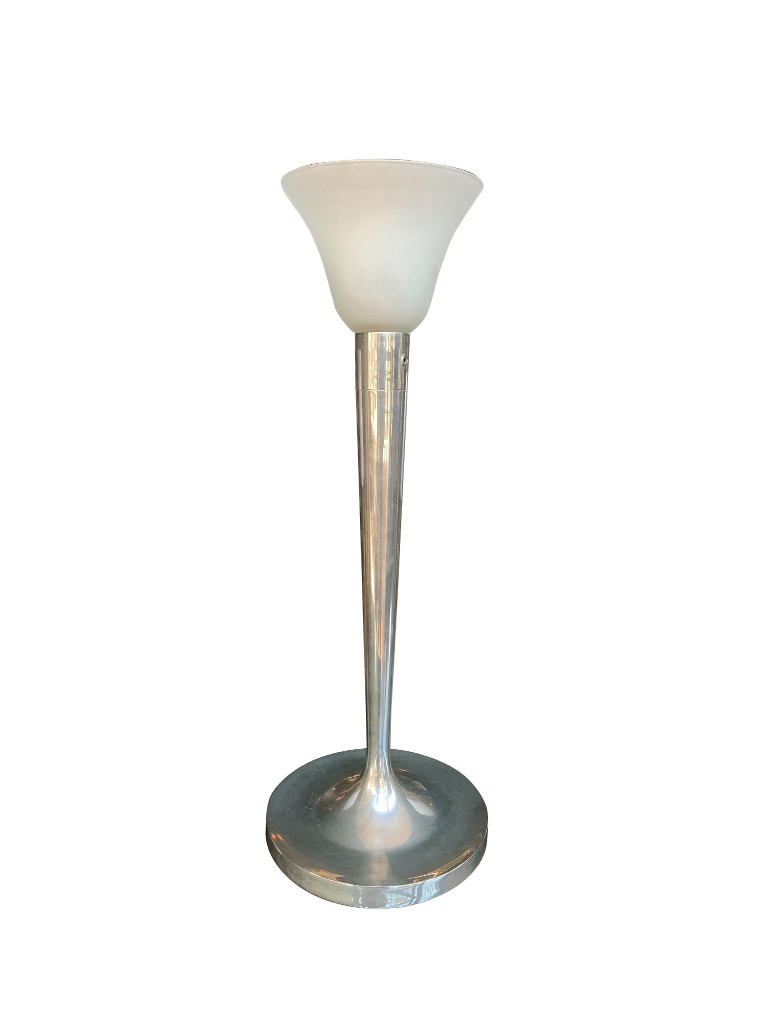 Designed by Jean Perzel, this Art Deco lamp consists of an aluminum body, aluminum shade, and frosted glass head. It has a single-bulb socket and cord-switch.

Dimensions:
28 in. overall height
10.5 in. base diameter
18.5 in. shade