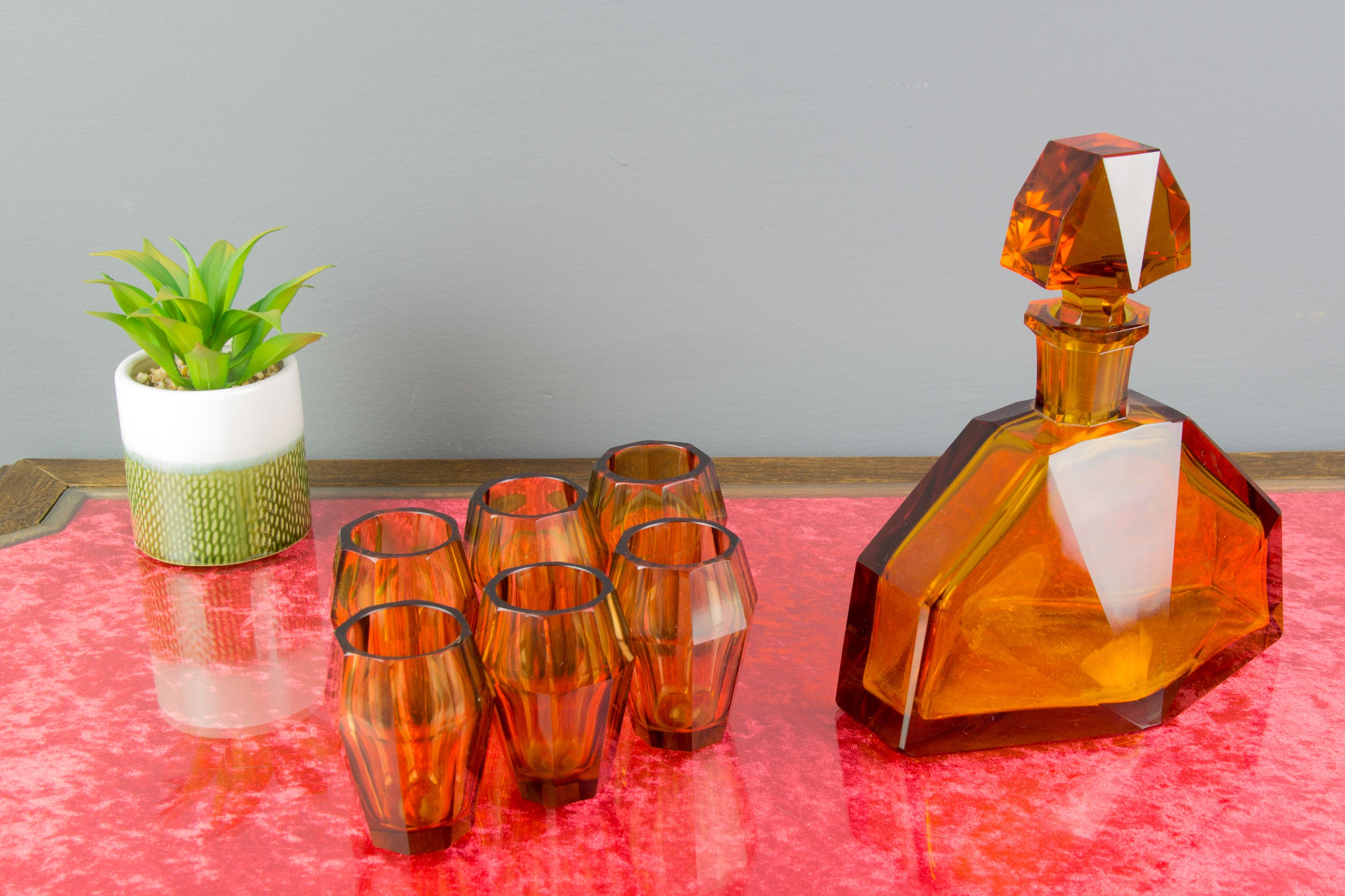 Beautifully colored, Czech Bohemian glass decanter set with 6 glasses, made in the 1930s. 
Dimensions: 
Decanter (including stopper): height: 20.5 cm / 8.07 in; width: 18 cm / 7.08 in; depth: 11 cm / 4.33 in.
Glasses: Dimensions: height: 7.5 cm /