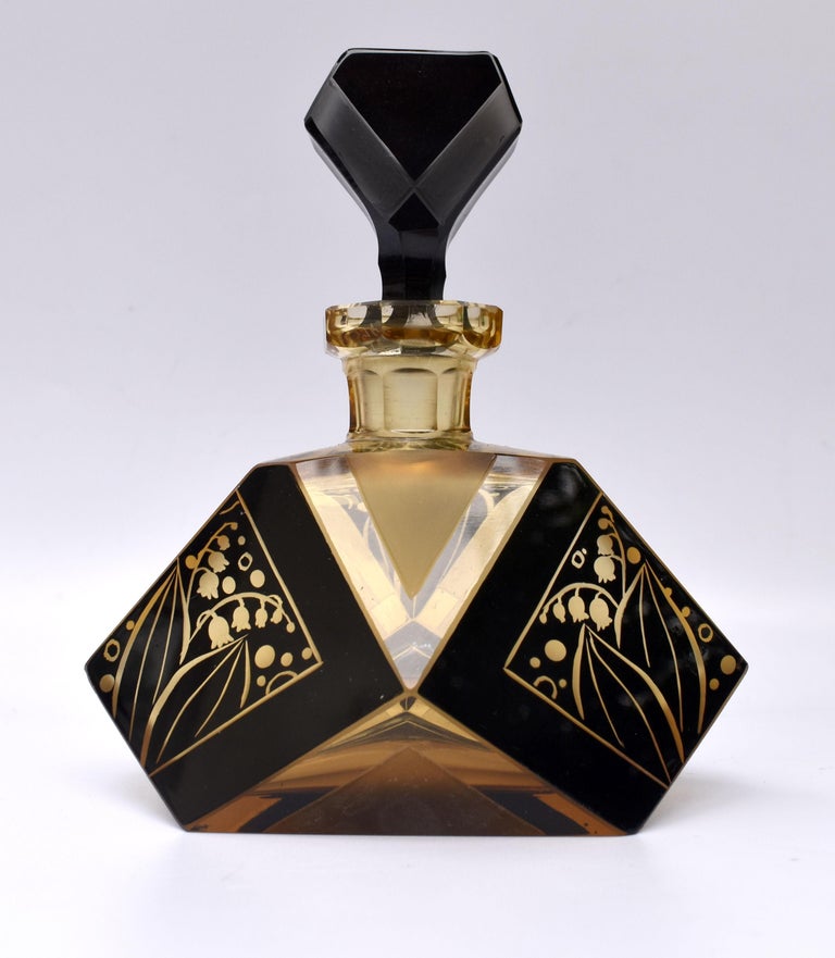 A truly beautiful Art Deco perfume bottle with a very attractive and iconic shape and patterning with geometric black enamel decoration to both the body of the bottle and stopper. Manufactured in Czech republic in the 1930s this stunning bottle is