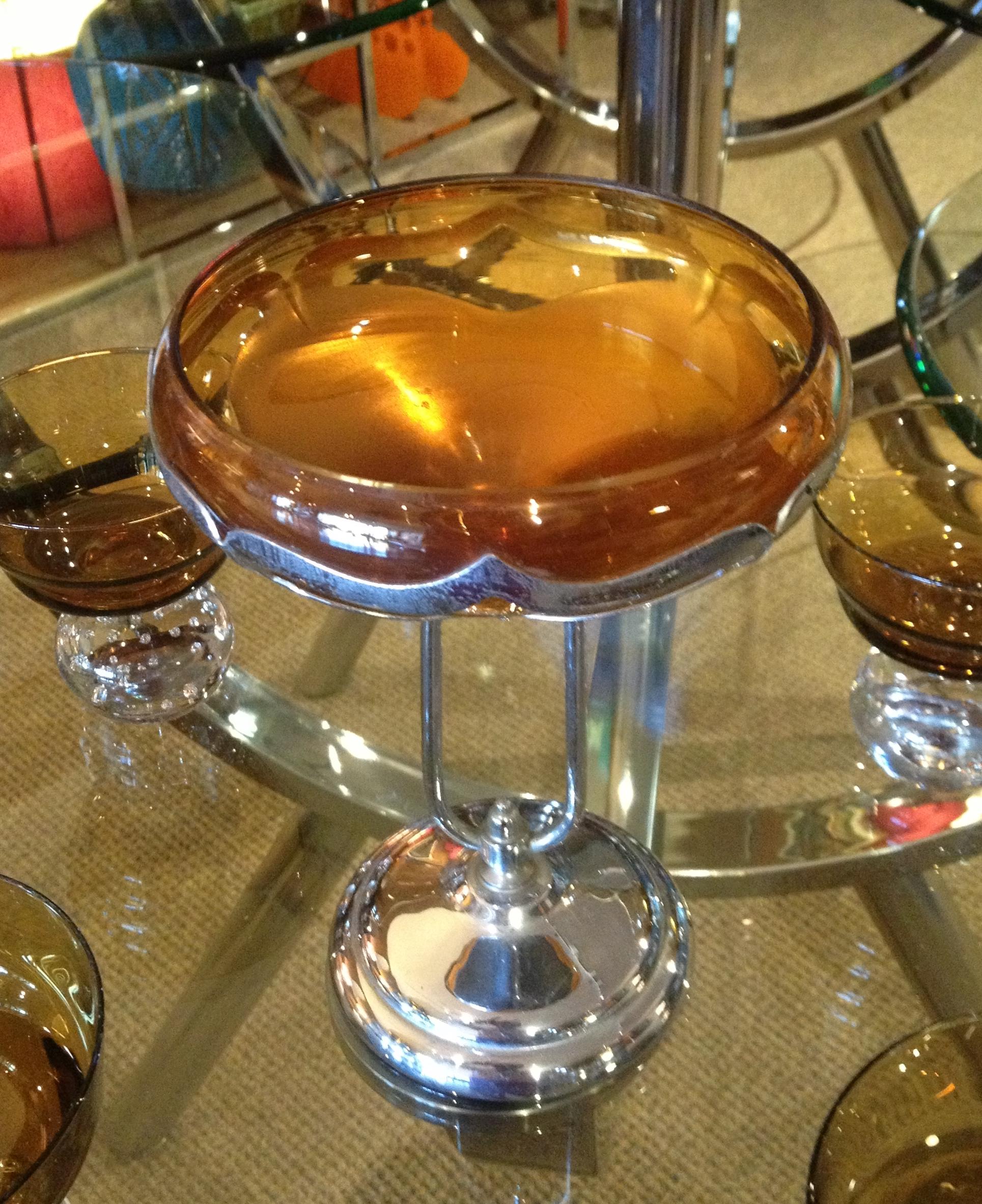 Elegant Art Deco / Hollywood Regency style compote made by Farber Bros., New York, ca. 1940s. Amber colored glass bowl, atop a gracefully curved pedestal, sits inside a chrome overly. A classic Farber Bros. style that is perfect for candy, nuts or