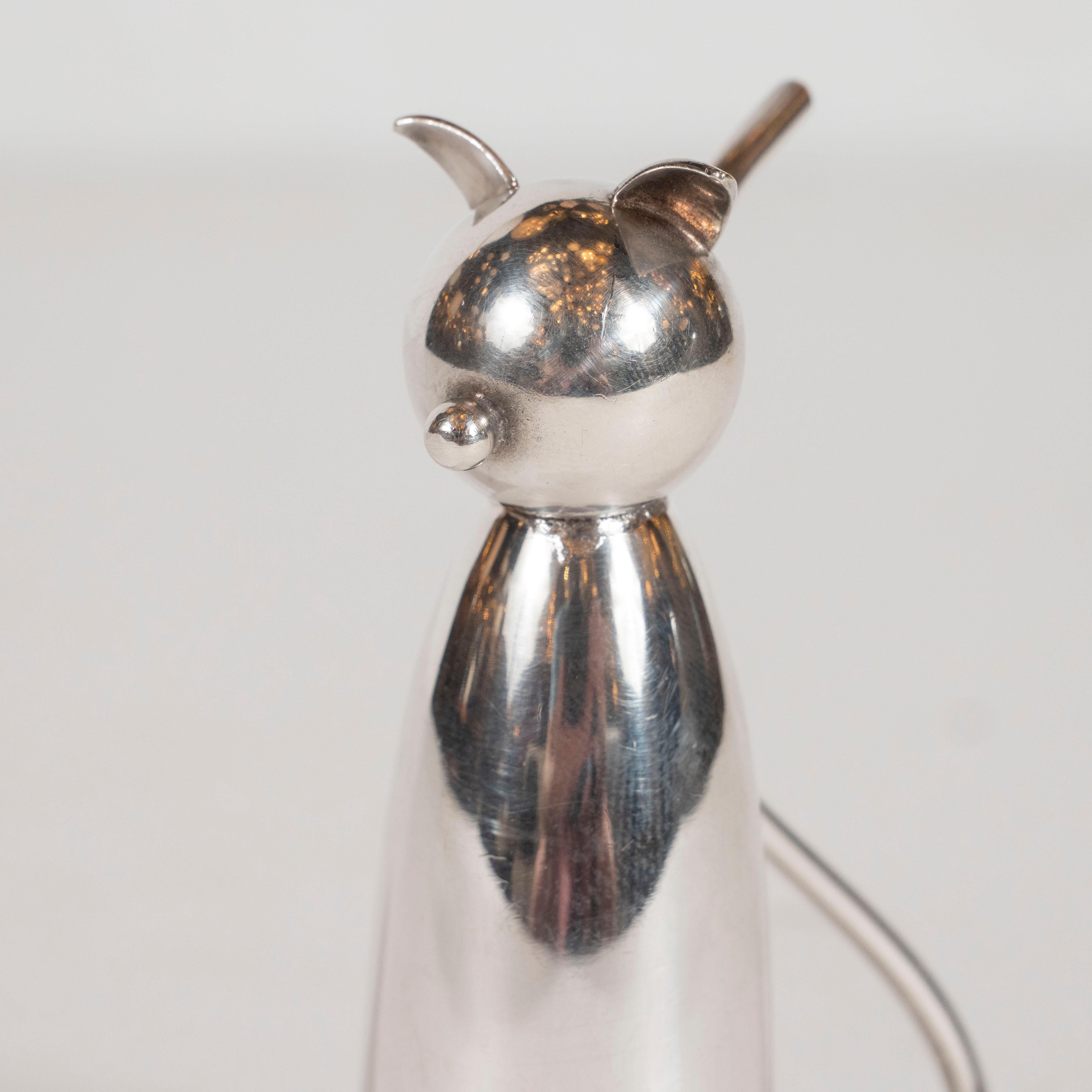 This Art Deco stylized cat jigger was realized in the United States, by the esteeemed maker Napier, circa 1940. It offer an abstracted cat form replete with an undulating tail, a button nose and streamlined ears all in silver plate. In order to use