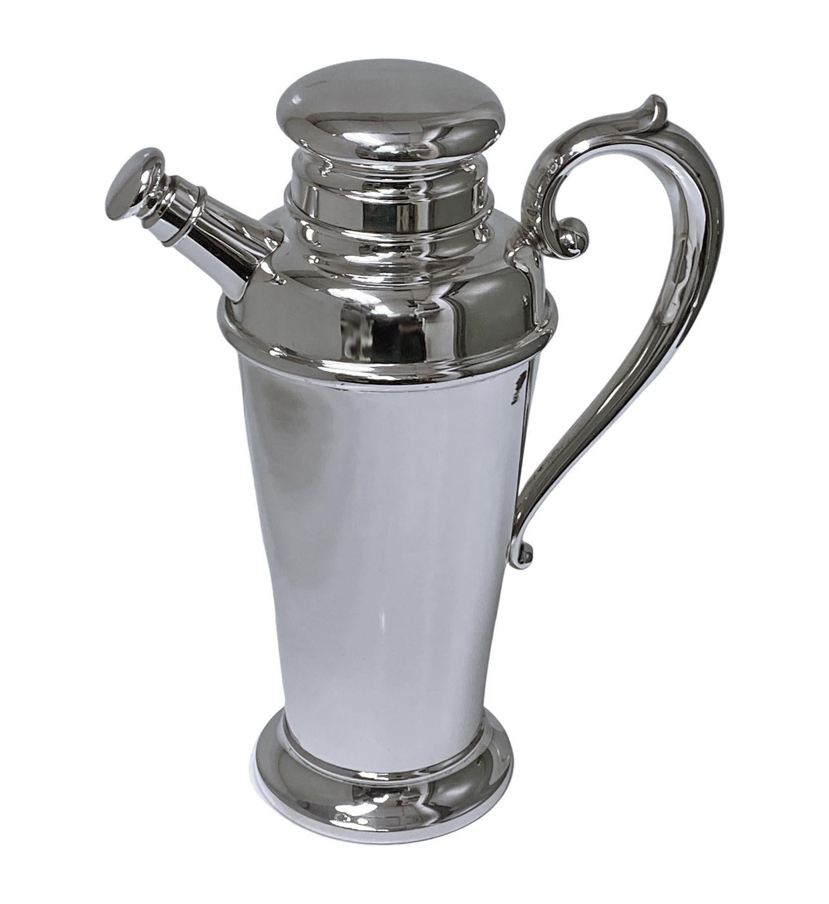 Art Deco American Sterling Silver cocktail shaker Manchester Silver Co C.1930. The shaker of plain tapering cylindrical form scroll handle, spreading circular foot, Removable pouring cover, pull-off domed lid. Height: 10.5 inches. Handle to spout: 8