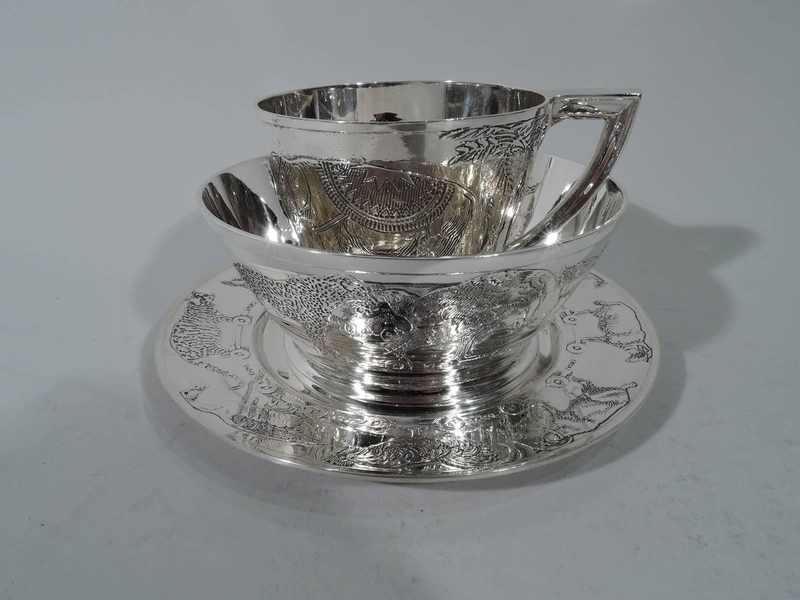 Art Deco three-piece sterling silver baby set. Made by Kerr in Newark. This set comprises cup, bowl, and plate. Plate has well. Cup and bowl are gently curved and tapering with raised foot. Modern forms acid-etched with animal parade: Exotic