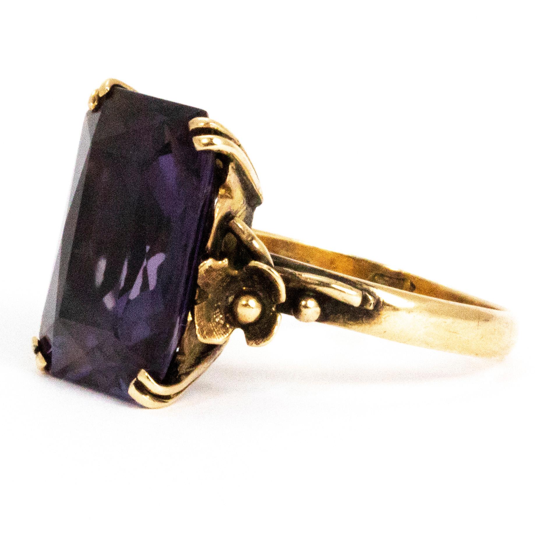 The deep purple of the amethyst next to the gold is stunning. This 9ct gold cocktail ring has so much detail in the setting. The stone is held by four double claws at the corners and either side of the stone are pretty flowers. Behind the stone the