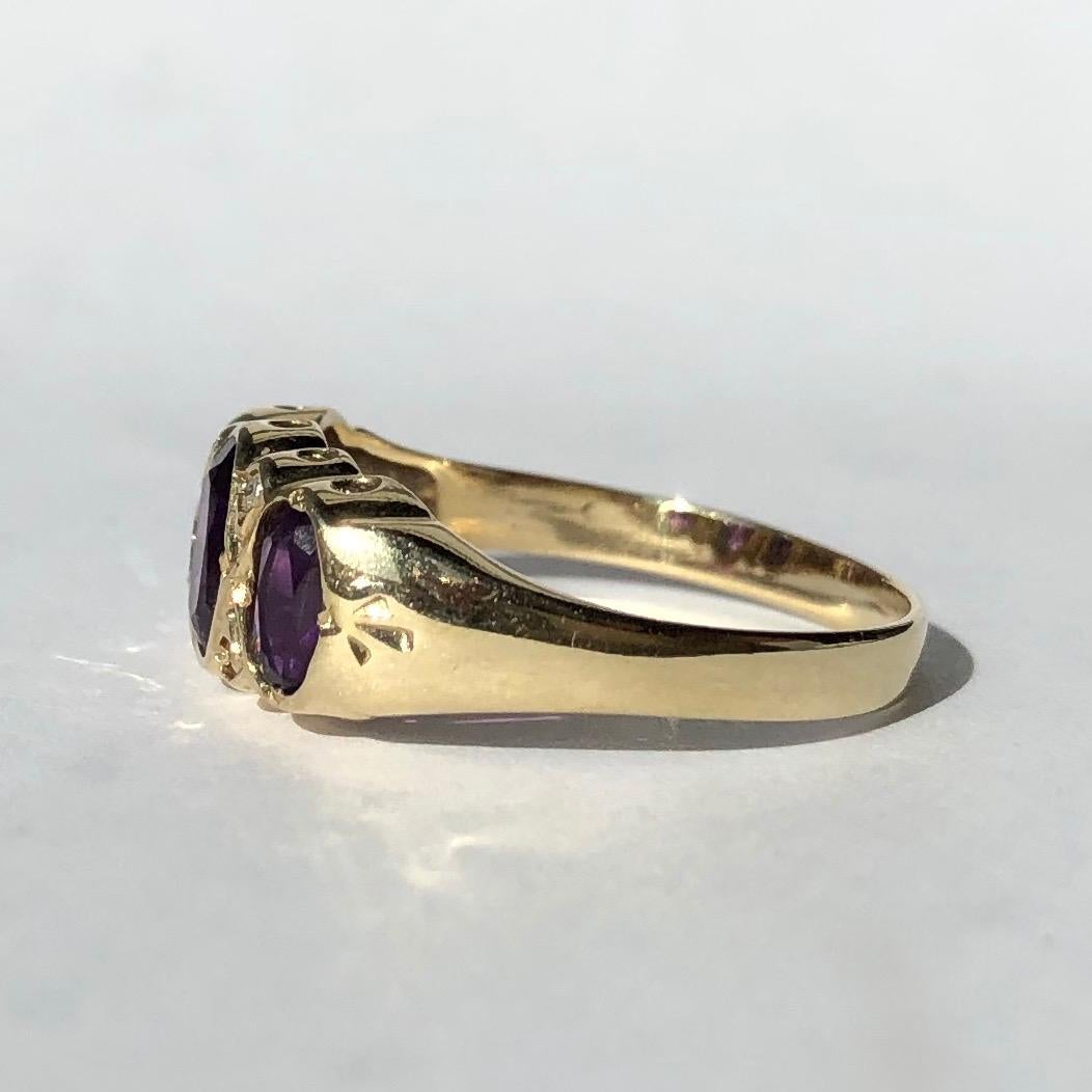 The three Amethyst stones in this band are a gorgeous bright purple colour and wither side of the larger centre stone are pairs of rose cut diamond points. The ring is modelled in 9carat gold and is smooth and glossy from the stone setting right
