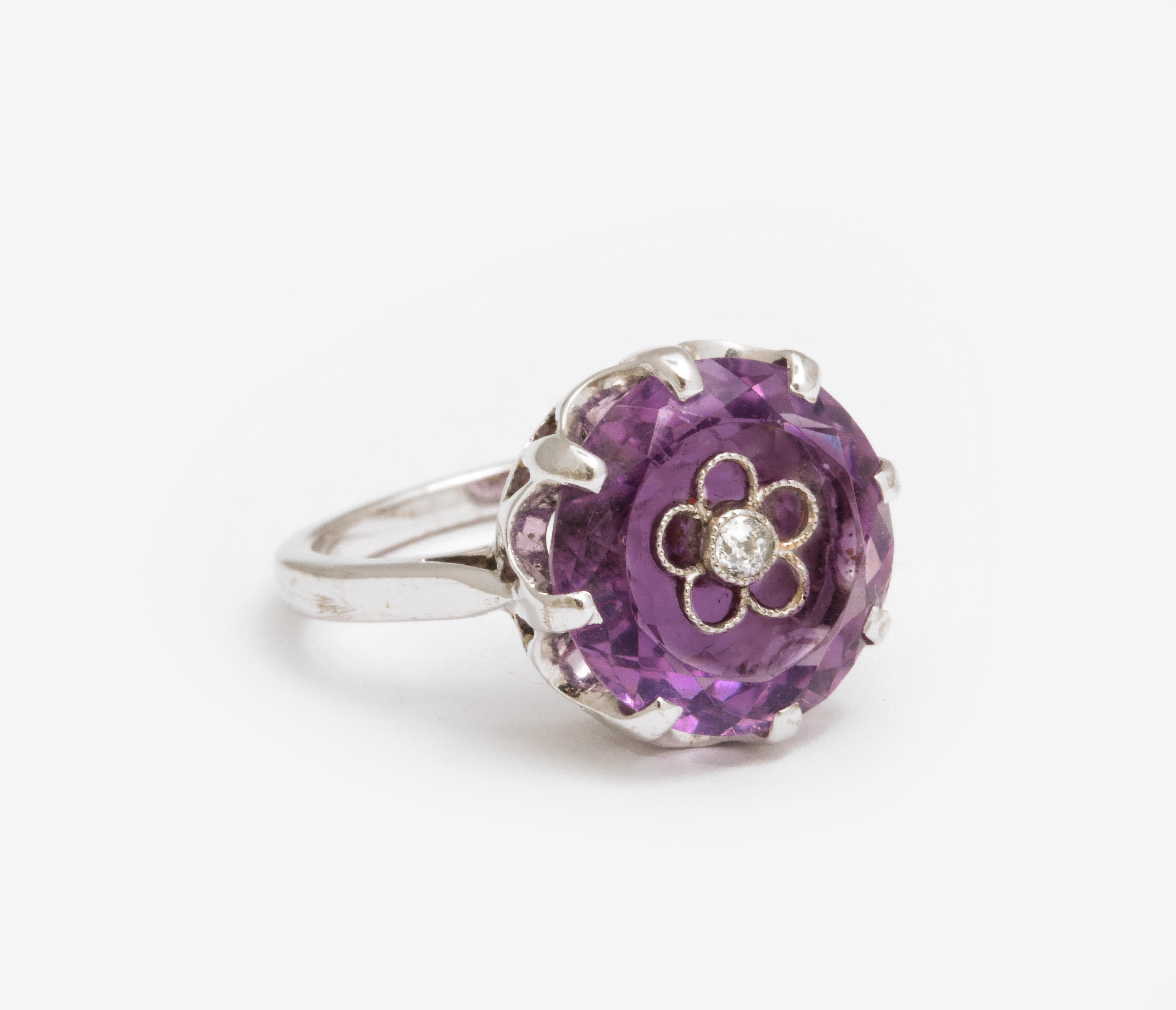 An Art Deco ring with a round 6 ct amethyst that has a posey on its wide table to signify 