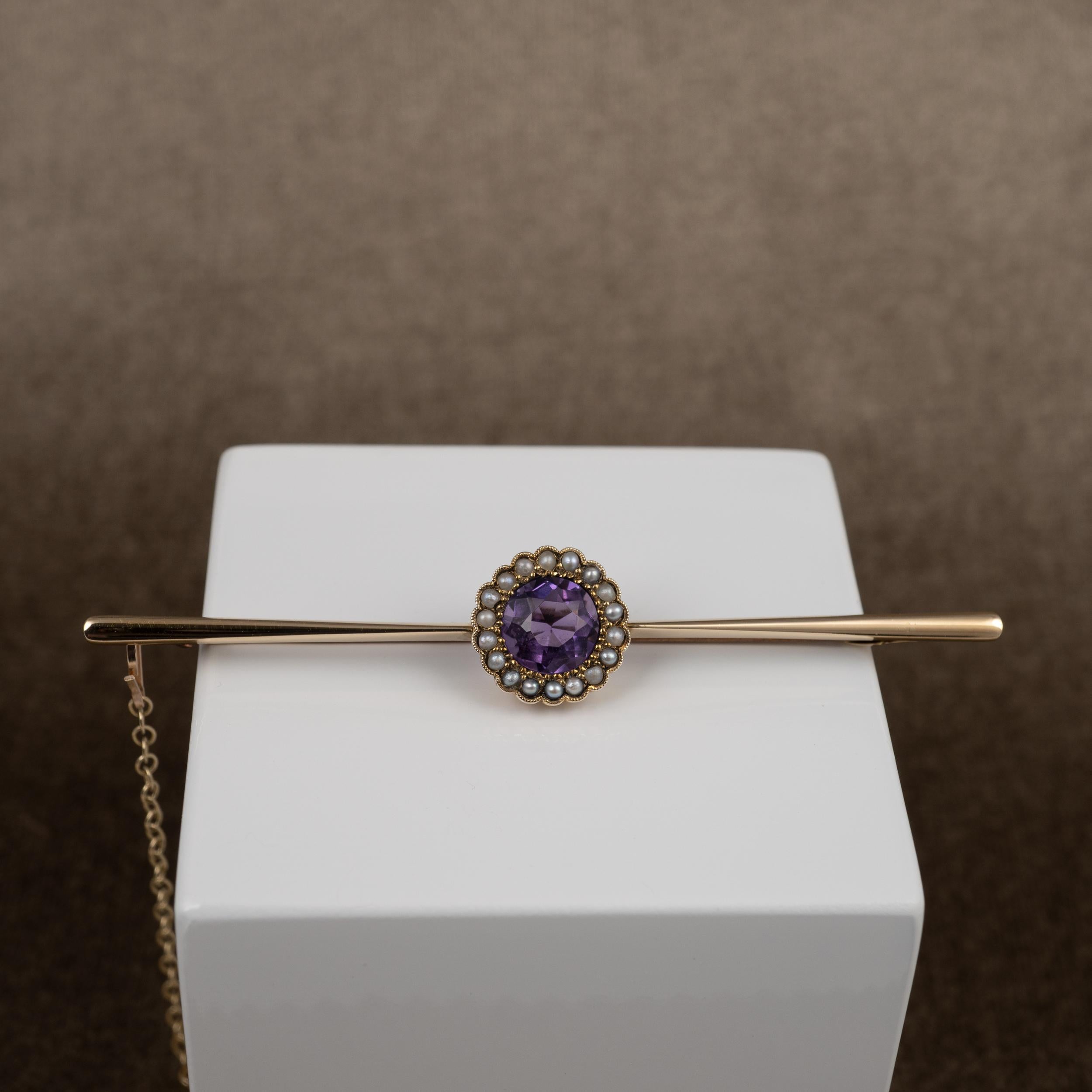 This elegant ladies antique brooch features a central setting consisting of a round cut amethyst with a surround of pearls.

The long brooch pin displays a central round facet cut amethyst which has a translucent but rich lilac purple colour. The