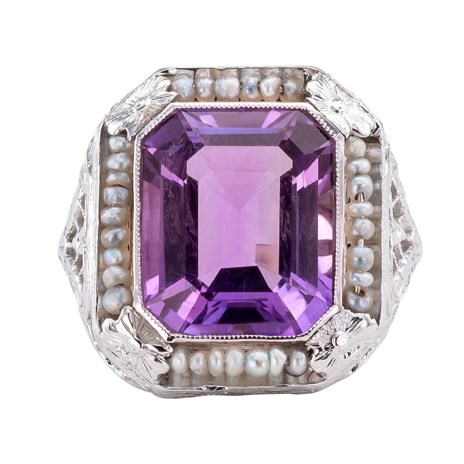 Art Deco amethyst seed pearl and white gold filigree ring circa 1930.

DETAILS:
GEMSTONES:  one emerald-cut amethyst and seed pearls.

METAL:  18-karat white gold

MEASUREMENTS:   Approximately 11/16” (17 1/4 mm) wide vertical to the