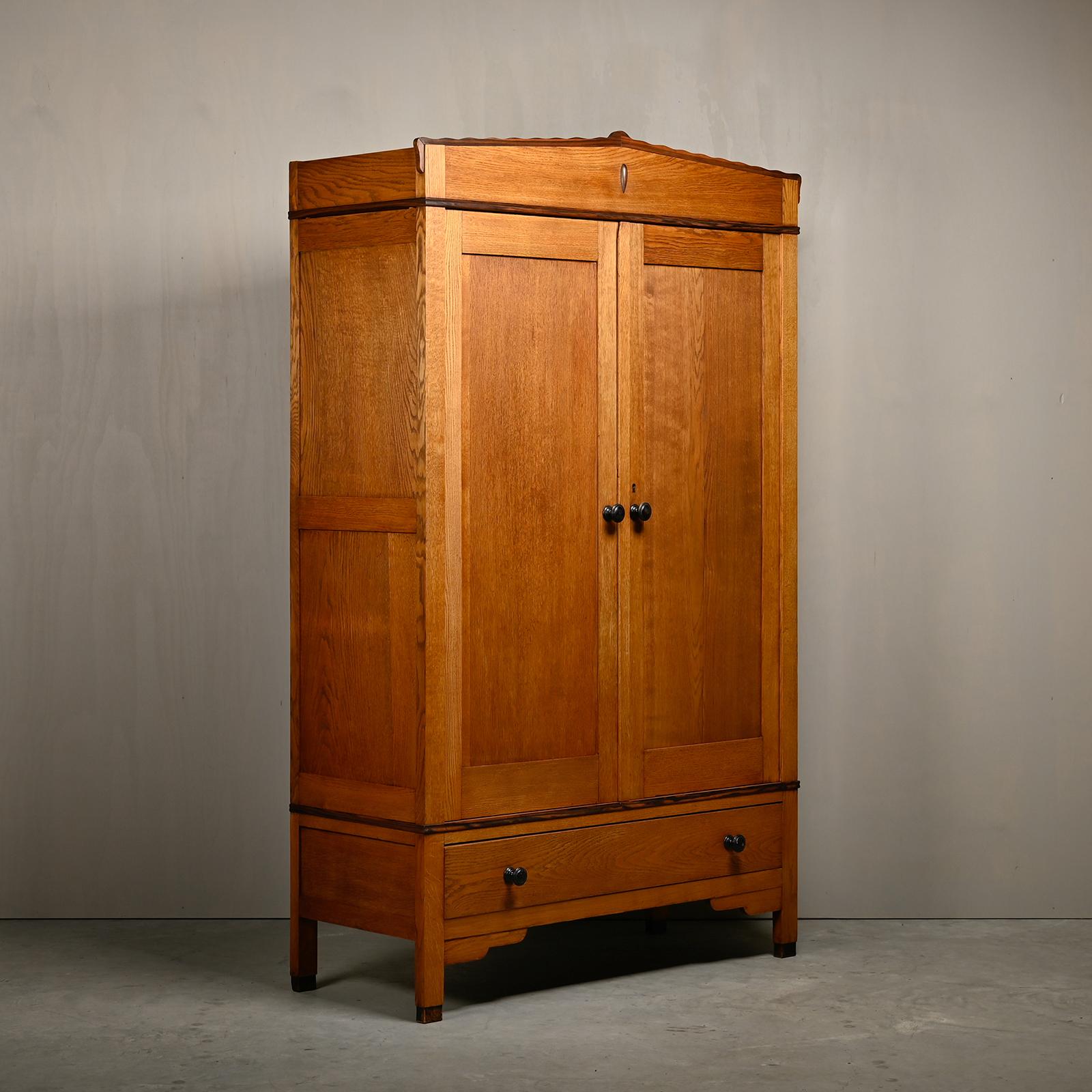 Beautiful Art Deco Amsterdam School Armoire or Wardrobe from 1928 by J.Th. Drilling jr. Solid oak base with macassar ebony decorative elements. Five adjustable shelves and two drawers. Original the right door had a facet-cut mirror, but is replaced