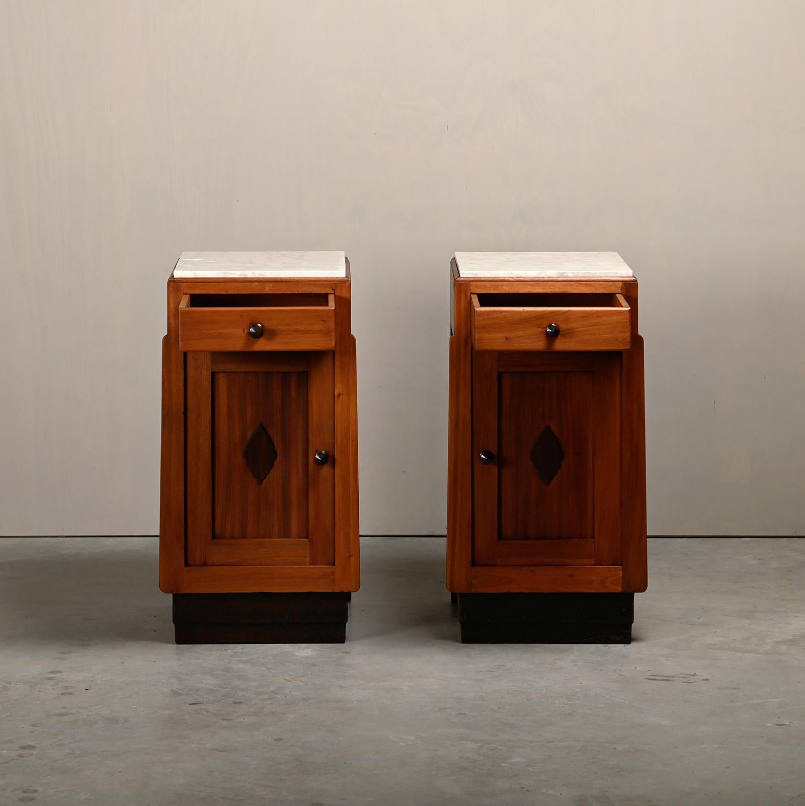 Very nice pair of Art Deco nightstands or bedside tables in the style of the Amsterdam School, Netherlands, 1930s. Solid wood bases and handles with marble tops in good original condition. Wear consistent with age and use, preserving a beautiful