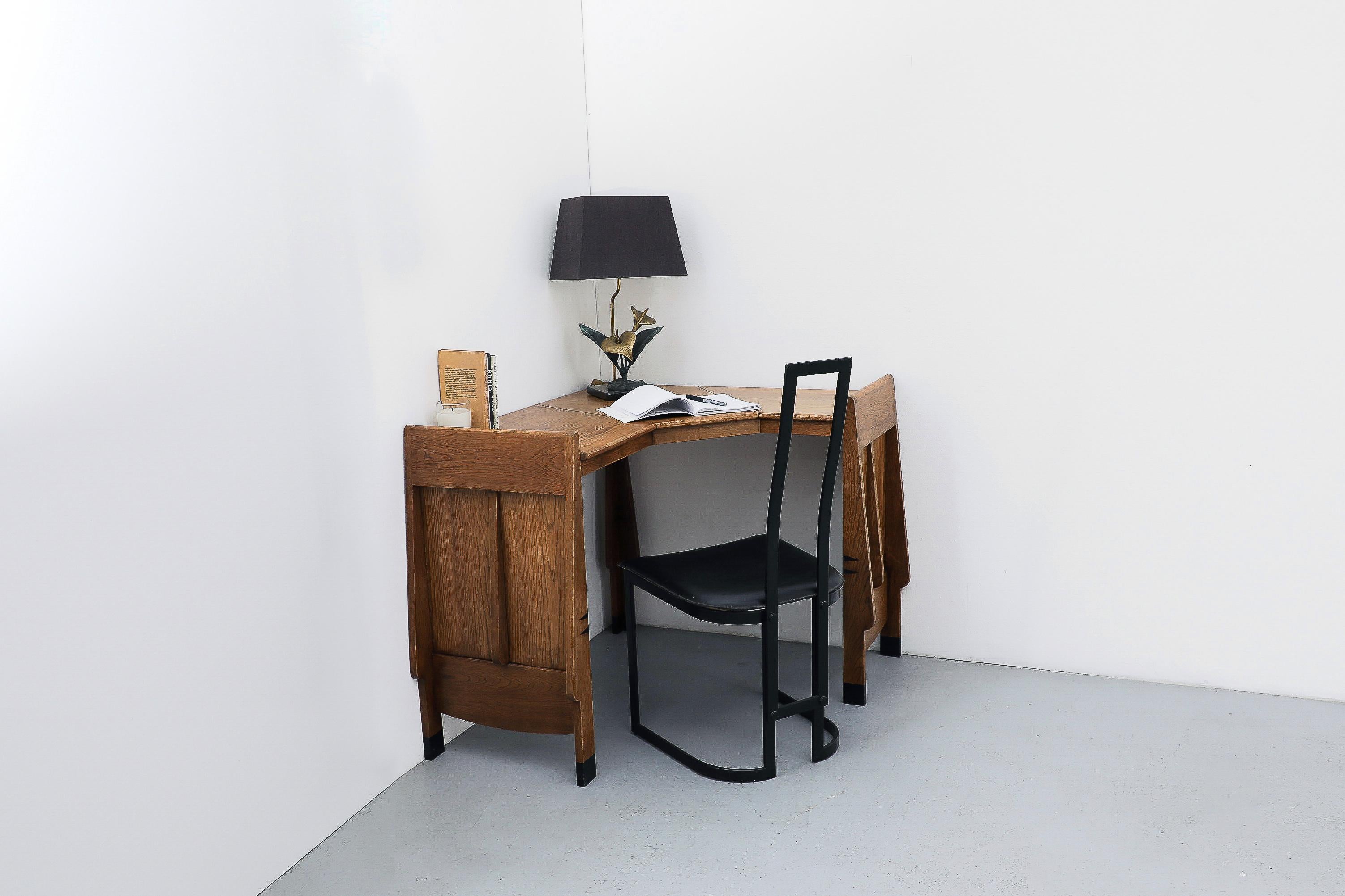 A remarkable example of Dutch design, this unique Art Deco 'Amsterdam School' corner desk is a piece of quiet authority, dating to the 1920s. The desk embodies the period's expressionist movement with its commanding geometric form and warm oak