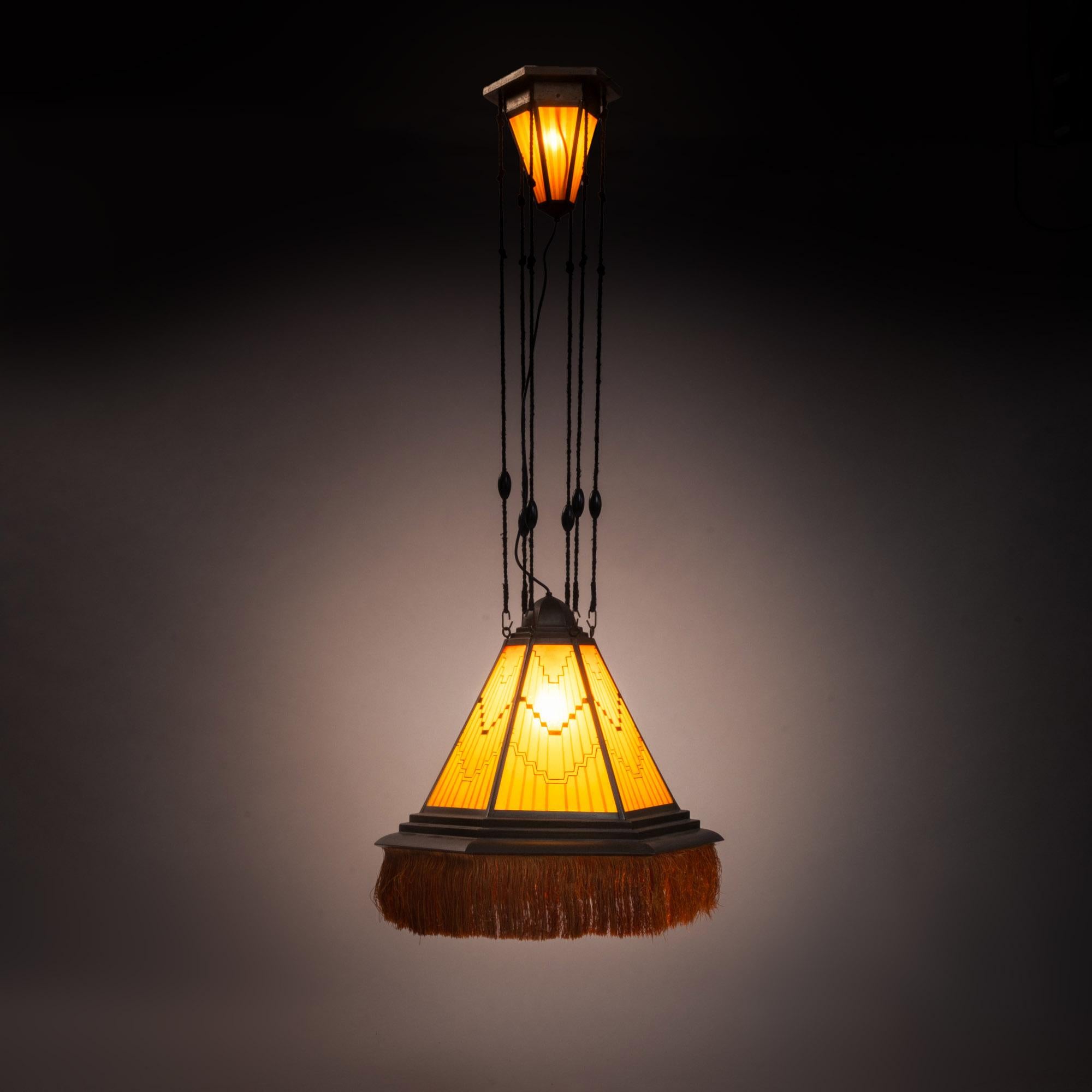 Amsterdam School hanging lamp, The Netherlands, 1930s
Hexagonal pendant lamp with glass.
The glasses are painted in black, red, red-brown, yellow.
Glasses hang in a copper frame.
The shade hangs on black rope.
The attachment points of the rope are