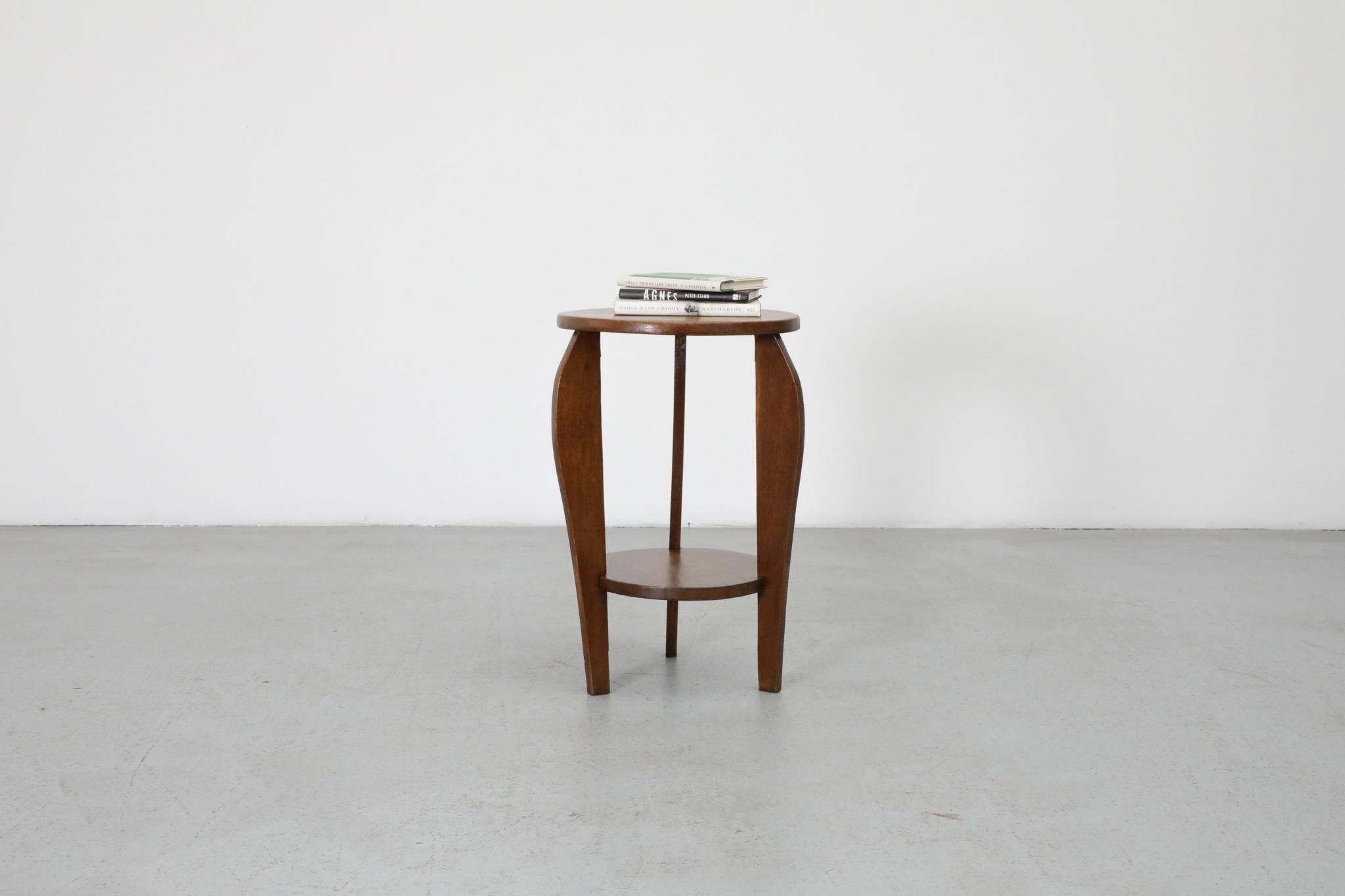 Bellissimo tavolino Art Deco della Scuola di Amsterdam con gambe splendidamente ricurve e un piccolo ripiano inferiore. Delicatamente    gambe ricurve con piano rotondo e venature dettagliate di Oak.  In condizioni originali con usura visibile, 