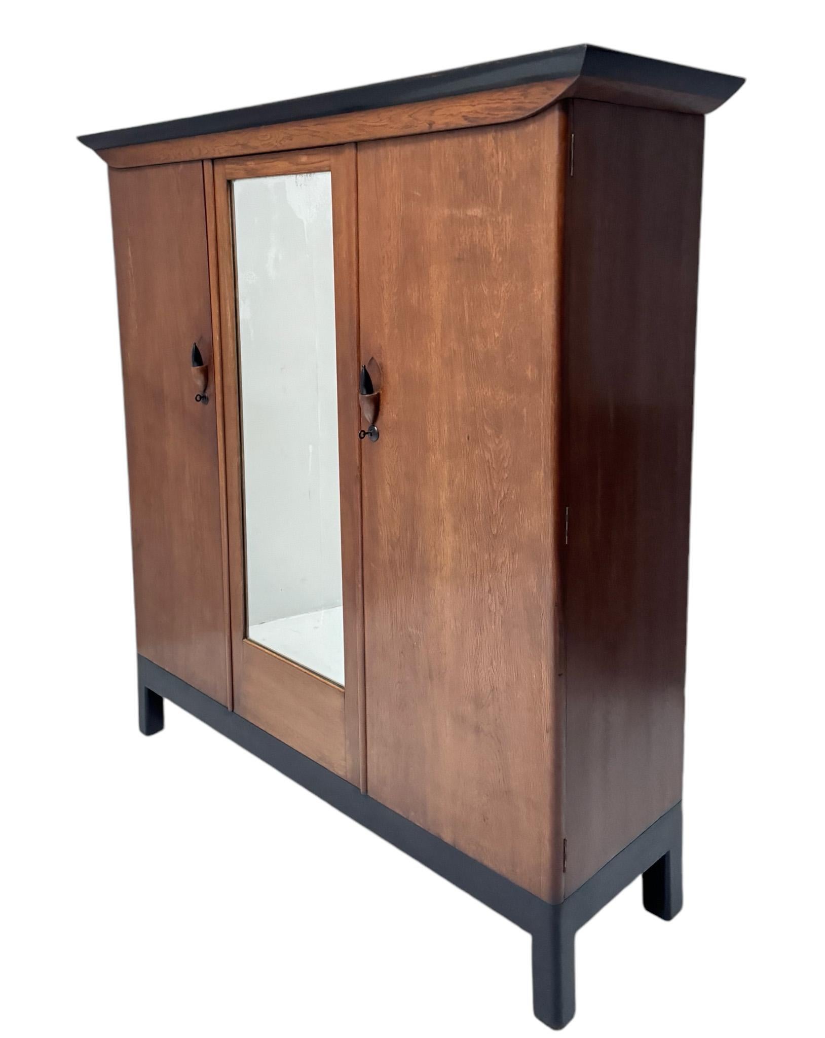 Magnificent and ultra rare Art Deco Amsterdamse School three- door armoire or wardrobe.
Design by Willem Penaat for Metz & Co. Amsterdam.
Striking Dutch design from the 1920s
Solid oak with original black lacquered decorative oak handles.
Original