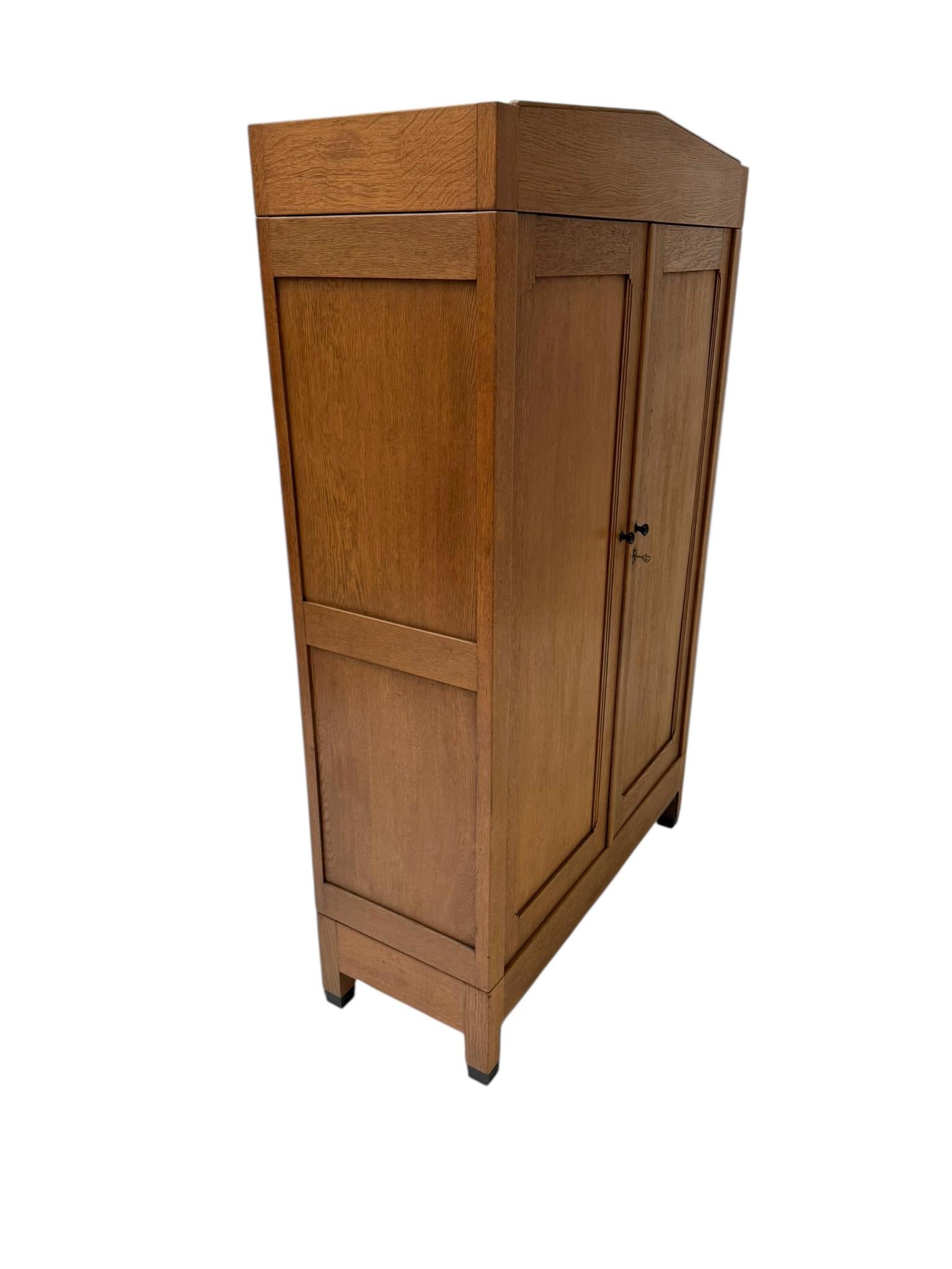 Stunning and elegant Art Deco Amsterdamse School armoire or wardrobe.
Striking Dutch design from the 1920s.
Solid oak with original solid macassar ebony knobs on both doors.
The two back panels are also made out of solid oak.
Three original solid