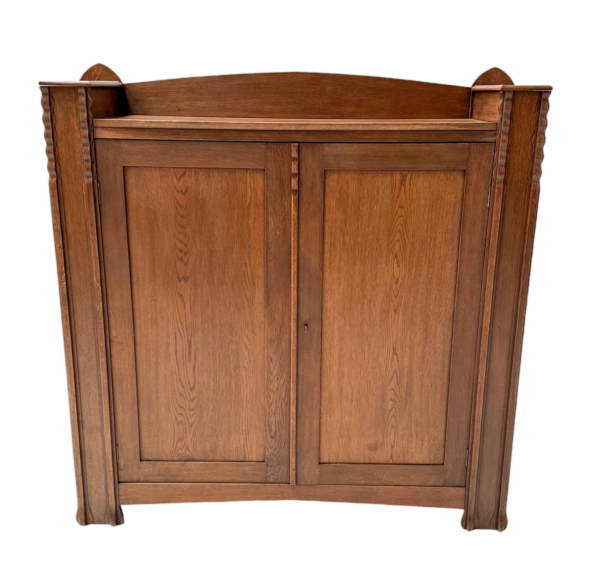 Magnificent and rare Art Deco Amsterdamse School bookcase.
Design by Piet Kramer.
Striking Dutch design from around 1916.
Solid oak base with on top two secret storage spaces.
Lock and original key are in good working order.
Behind the two doors,