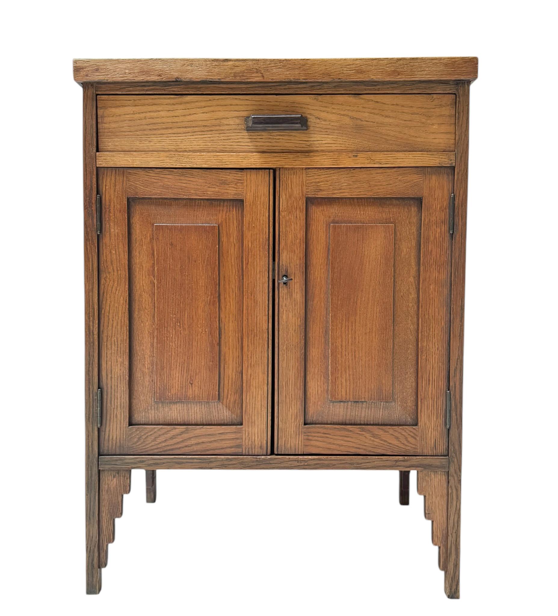 Stunning and elegant Art Deco Amsterdamse School cabinet.
Striking Dutch design from the 1920s.
Solid oak with original black lacquered top.
Behind the two doors, you will find one solid oak shelf.
Lock and original key are in good working