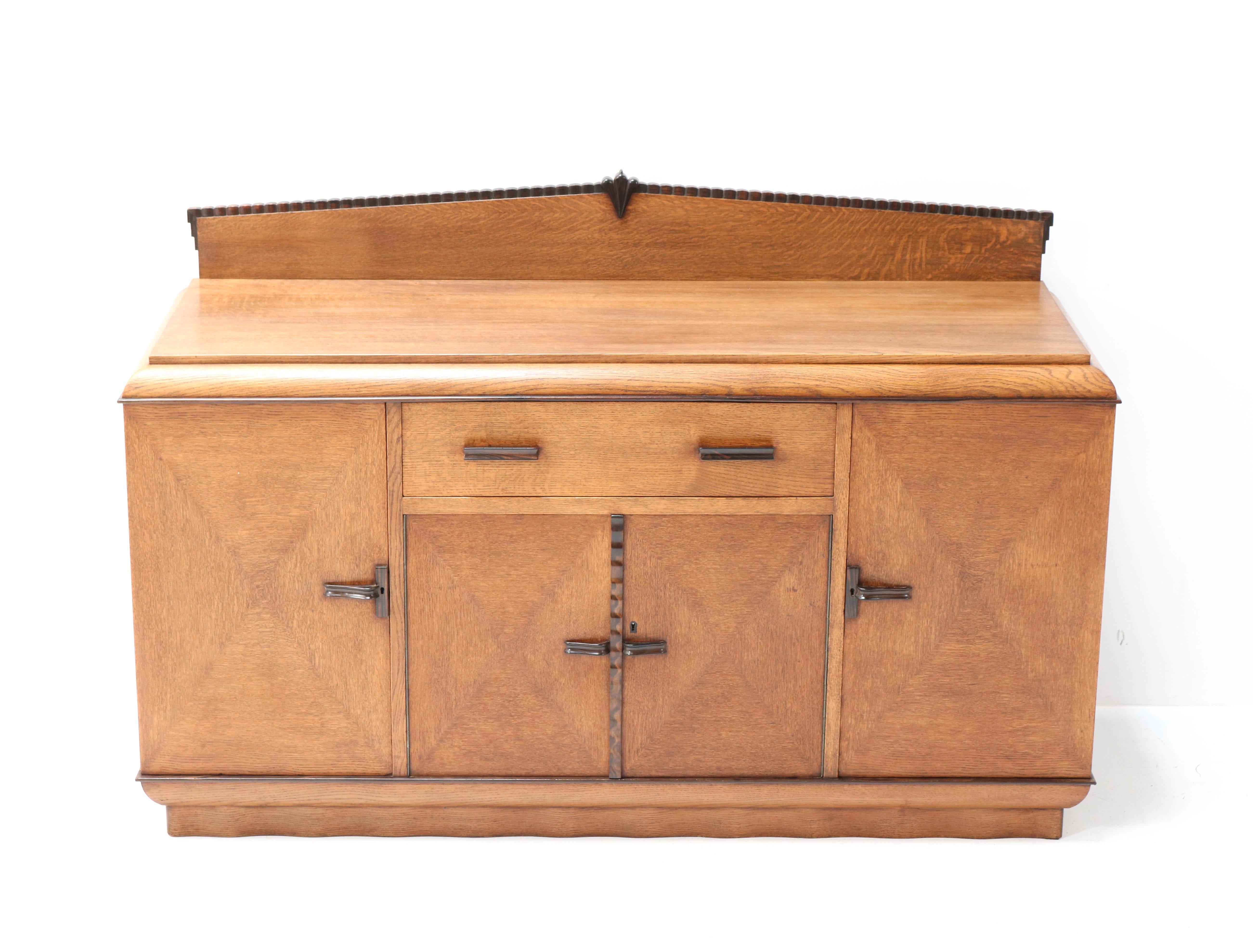 Stunning and rare Art Deco Amsterdam School credenza or sideboard.
Design by Fa. Drilling Amsterdam.
Striking Dutch design from the 1920s.
Solid oak with original solid macassar ebony handles and lining.
In very good condition with a beautiful