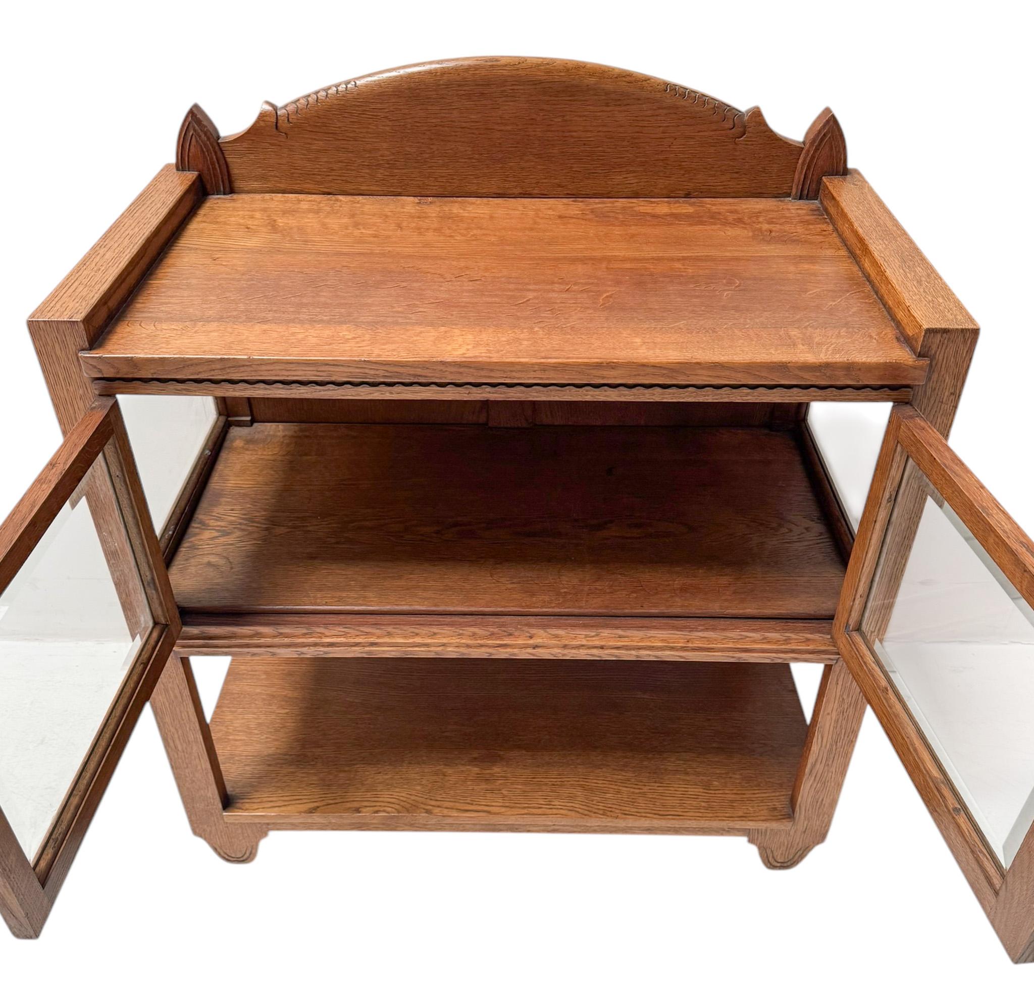 Magnificent and rare Art Deco Haagse School serving cabinet.
The design attributed to Hildo Krop.
Striking Dutch design from the 1920s.
Solid oak frame and the two doors still have the original beveled glass!
The two stylish hand-carved handles on