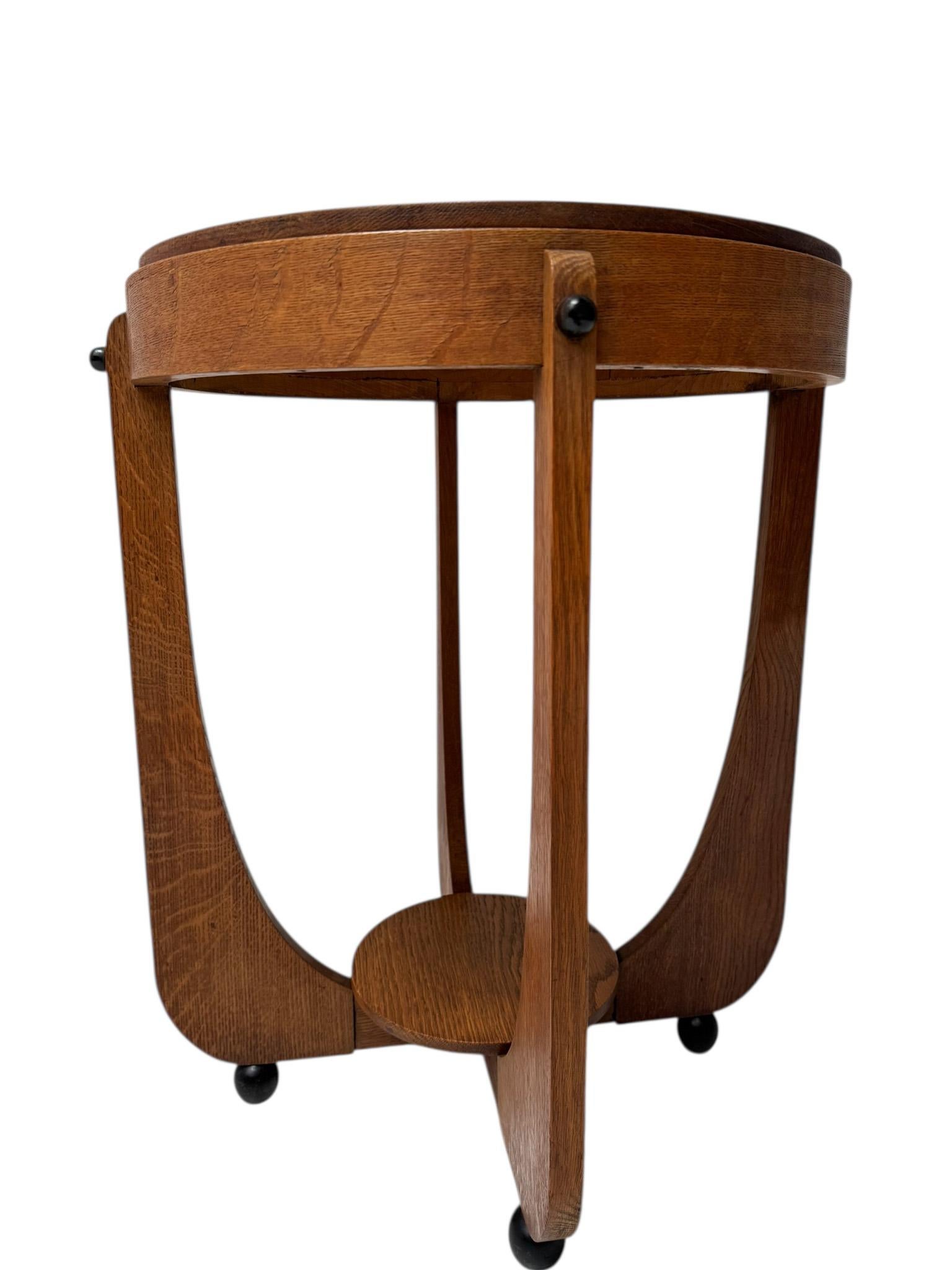 Stupefacente ed elegante tavolino Art Deco Amsterdamse School.Design olandese degli anni '20.Base e piano in rovere massiccio con elementi originali laccati in nero.Diametro del piano: Diametro del piano: 49 cm.Questo meraviglioso tavolino Art Deco