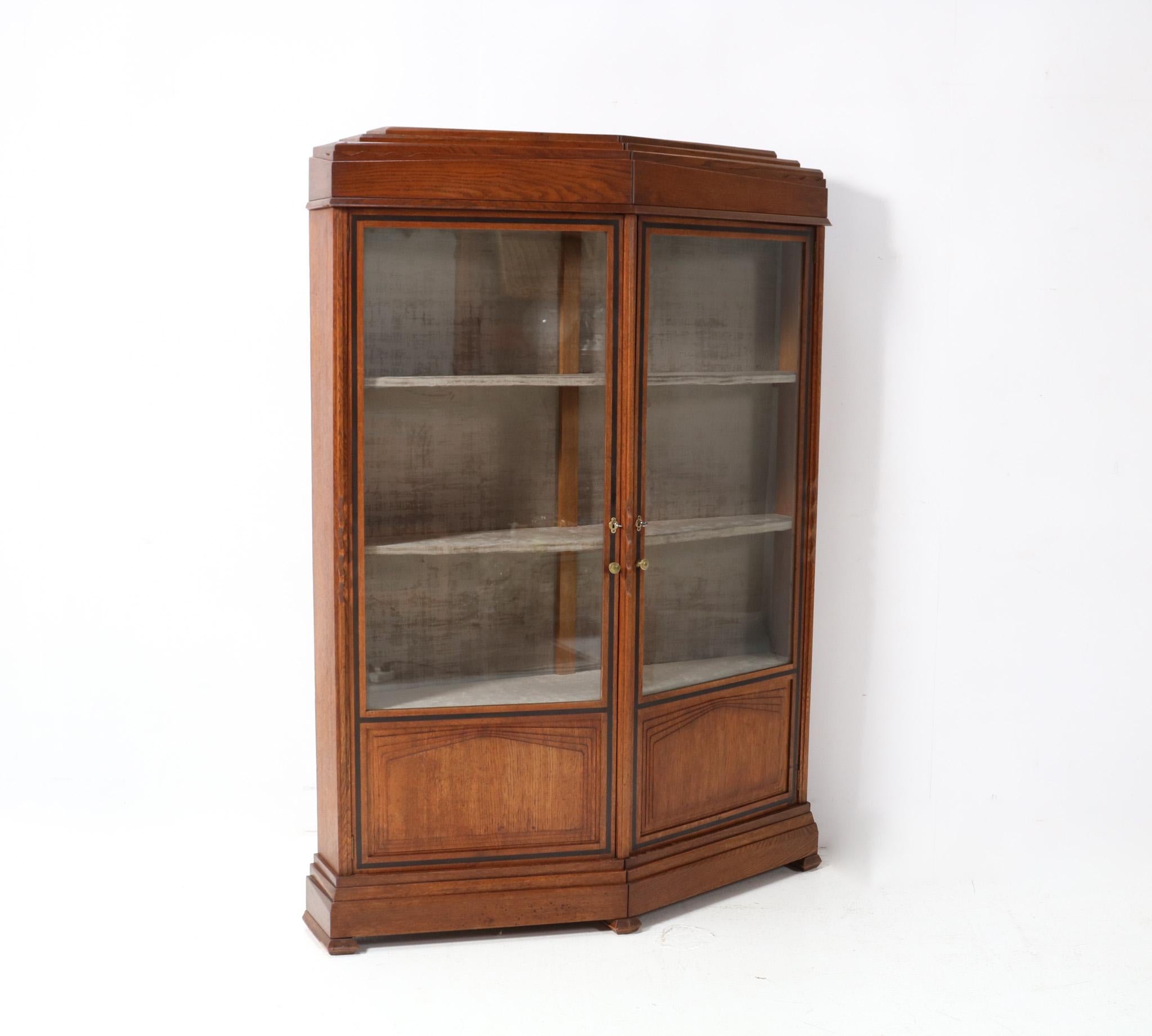 Magnificent and ultra rare Art Deco Amsterdamse School vitrine or display cabinet.
Design by Cornelis van der Sluys.
Striking Dutch design from 1918.
Solid oak with typical decorative Amsterdamse School elements and original brass key entrances.
The