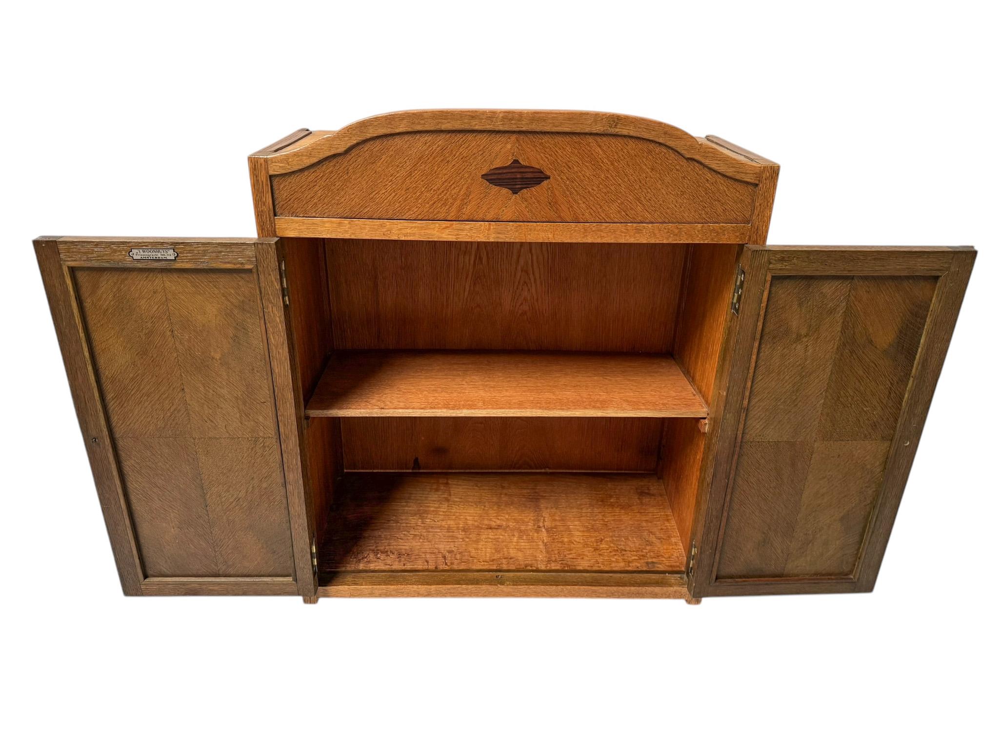 Splendido ed elegante armadio a muro Art Deco della Scuola di Amsterdam.Design di 't Woonhuys Amsterdam.Straordinario design olandese degli anni '20.Base in rovere massiccio con pomelli originali in ebano macassar su entrambe le ante.Marcato con