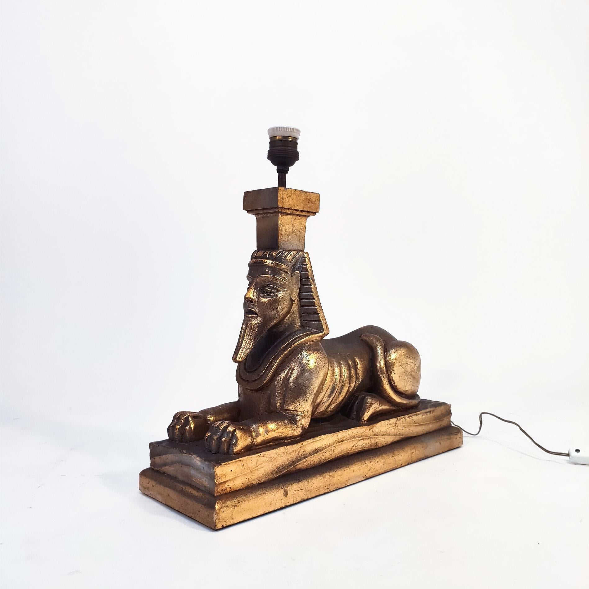 Mid-Century large hand-carved wooden table lamp, Spain, 1960s. Polychromed wood body in gold representing an Egyptian sphinx, and brass upper structure. This type of Egyptian lamps and decorative elements from Old Egypt became very popular in the