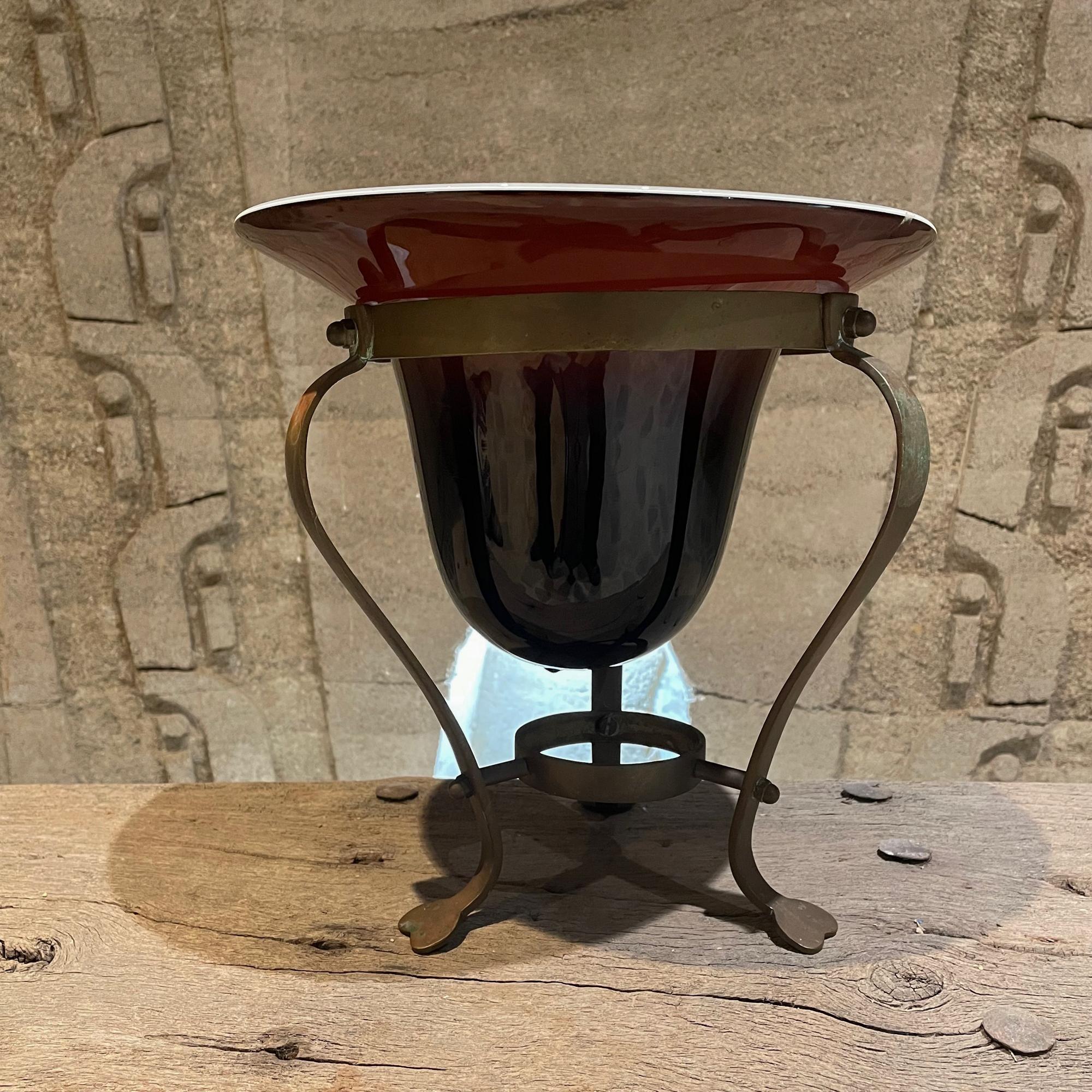 AMBIANIC offering:
Art Deco Decorative Vase Antique Handblown Glass Pedestal Bowl or Catch All Piece Platform of Solid Bronze USA 1940s.
Unmarked.
Dimensions: 11.25 H x 11 inches in diameter
Original vintage unrestored preowned condition. Patina is