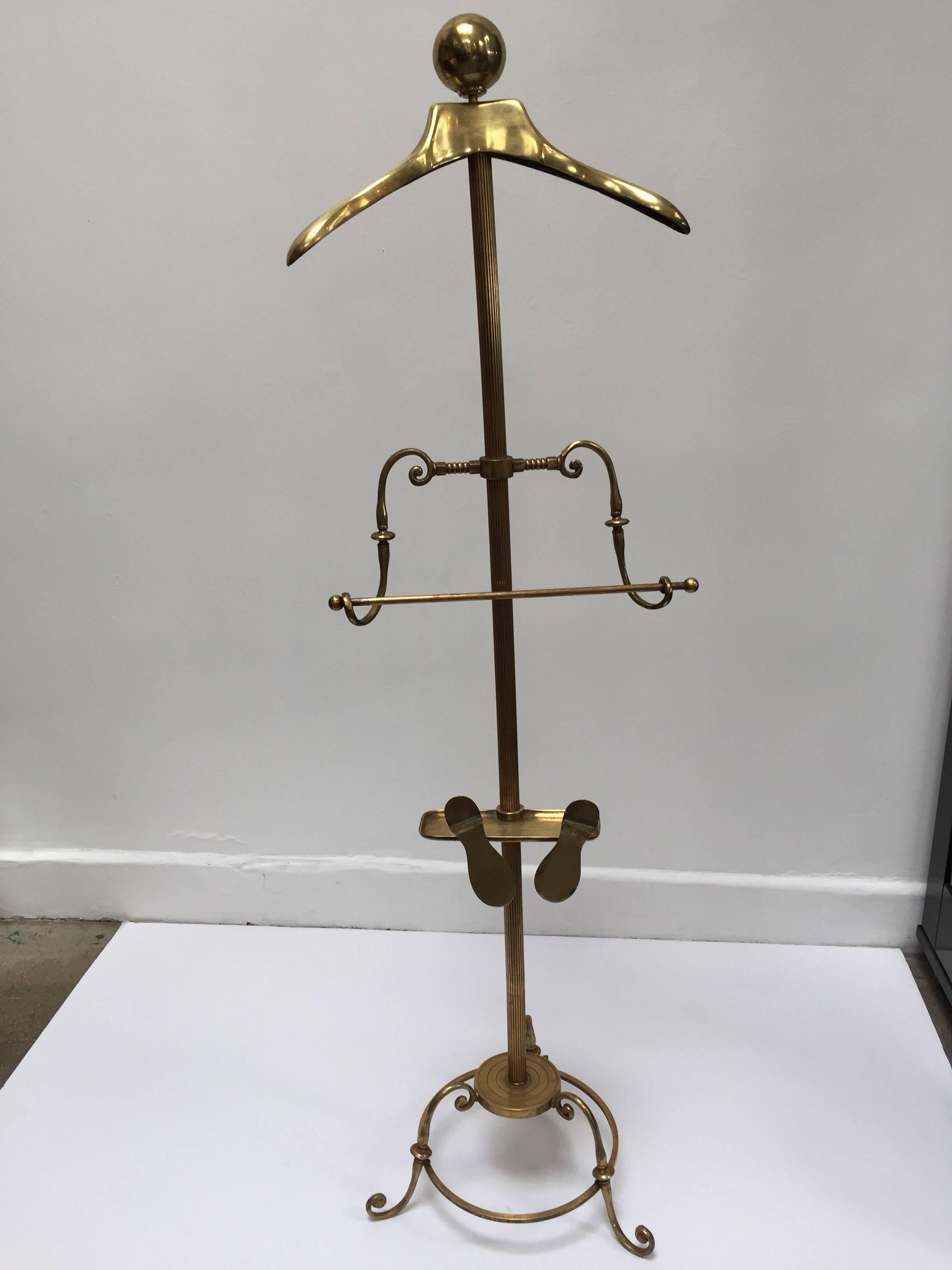 Valet en laiton poli Mastercraft Art Deco antique gentleman.
Cette pièce ancienne a été polie et est prête à vous aider à ranger, organiser et présenter une tenue complète. 
Un cintre pour la veste, un porte-pantalon, un bouton pour le chapeau et