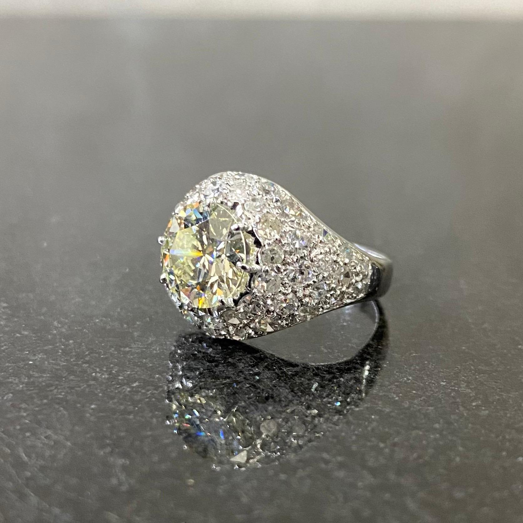 Art-Deco-Ring mit sehr hellgelbem Altschliff-Diamant und farblosem Diamant in Platin, Portugal, 1920er Jahre. Dieses antike Schmuckstück zeigt einen Diamanten im alten europäischen Brillantschliff, der in der Mitte in einer Kralle gefasst ist,