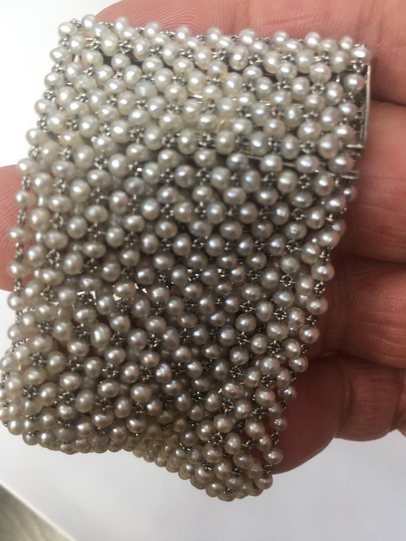 This stunning American made Art Deco Platinum Pearl Bracelet from 1920s is a beautiful and unique piece of antique jewelry. With a weight of 42 grams and a length of 7 inches, it features a slide closure and measures 1.75 inches wide. This bracelet