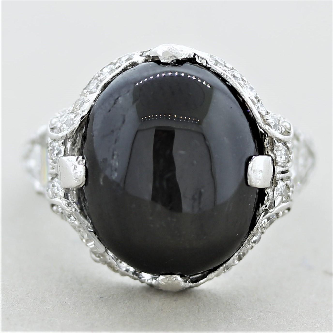 A fine antique from the Art Deco era, circa 1920, in original condition. It features a black star diopside which shows a 4 rayed star when a light shines over the stone. It is accented by trapezoidal and round-cut diamonds set around the ring in a
