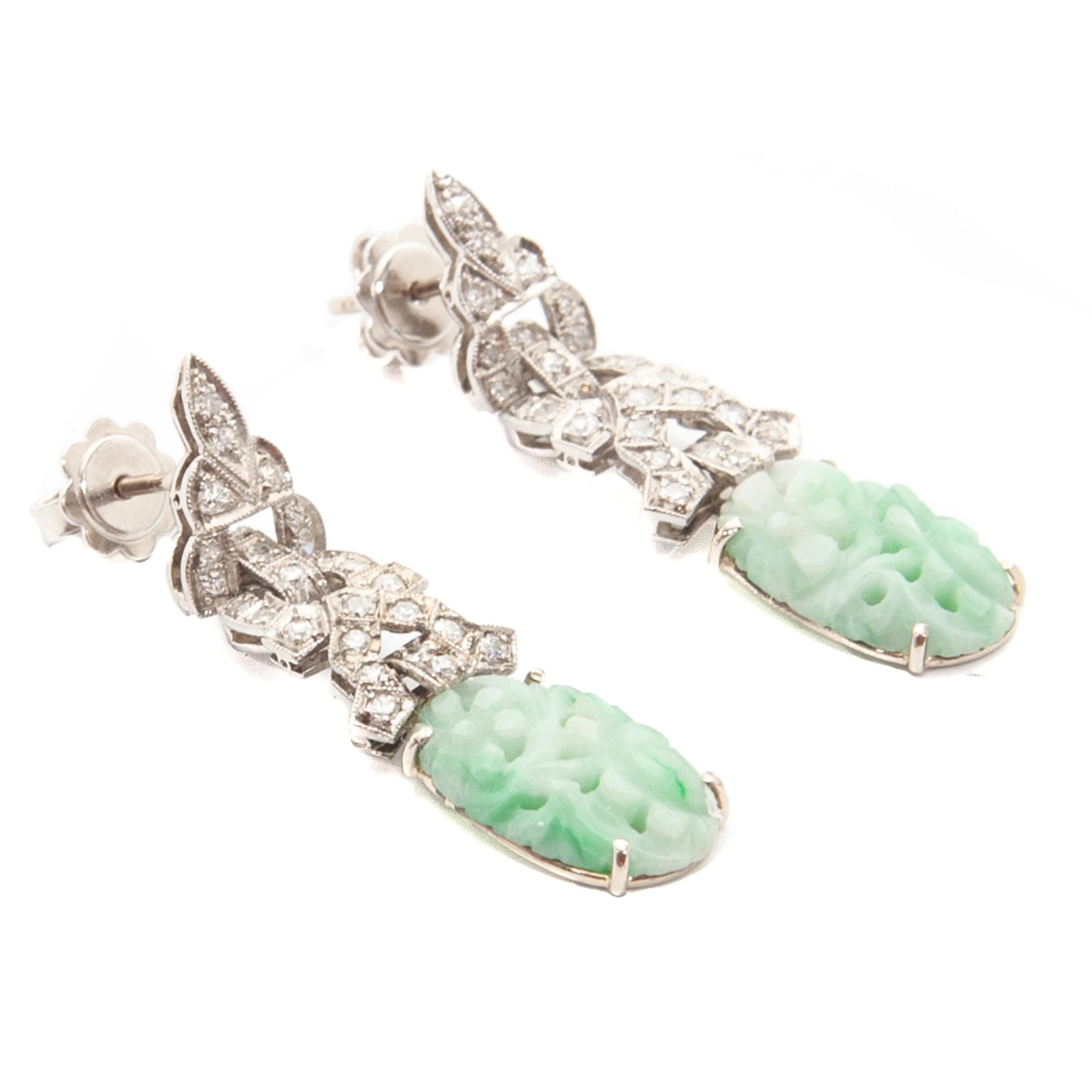 Magnificent Art Deco 1920s 14 karat white gold drop earrings, with each twenty-six octagonal cut diamonds. These earrings have gorgeous and delicate oval-shaped and carved jade. The diamonds are approximately 0.50 in carat, content 0.585. 

These