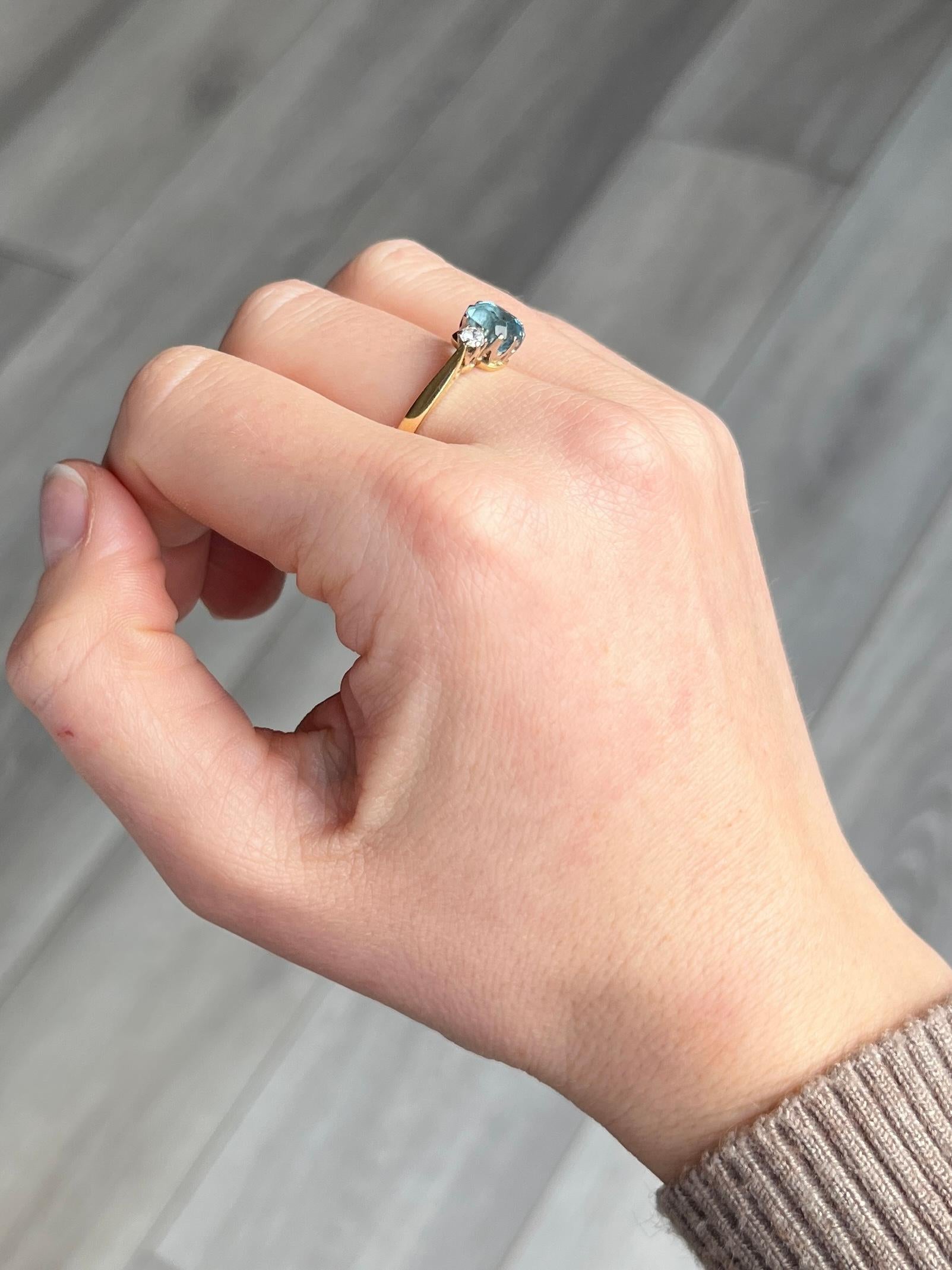 The gorgeous aqua stone in this ring is bright and has a diamond set either side. The aqua measures approx 1 carat and the diamonds measure 10pts each. The ring is modelled in 18 carat gold and the settings modelled in platinum. Stamped '18CT'.