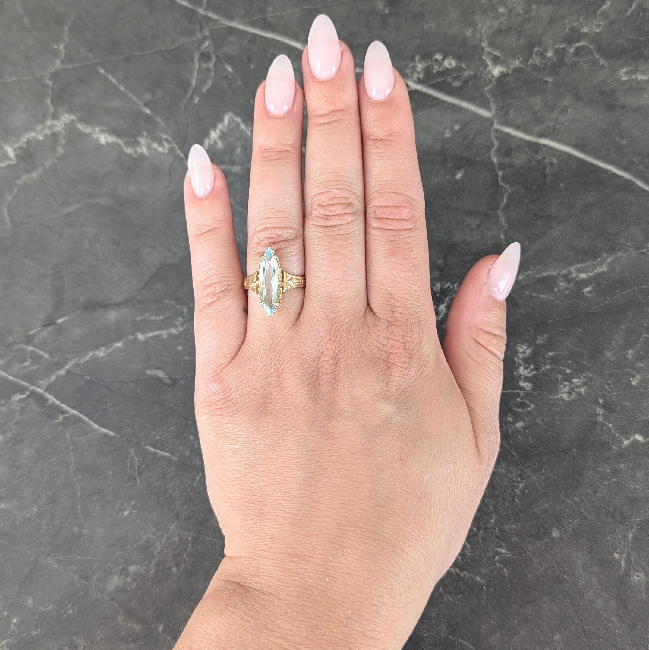 Centering a marquise cut aquamarine weighing approximately 2.08 carats
Transparent light blue and set by talon prongs in a scalloped mount
Flanked by flared gold shoulders engraved with arrow motif
Completed by gold shank
Tested as 14 karat