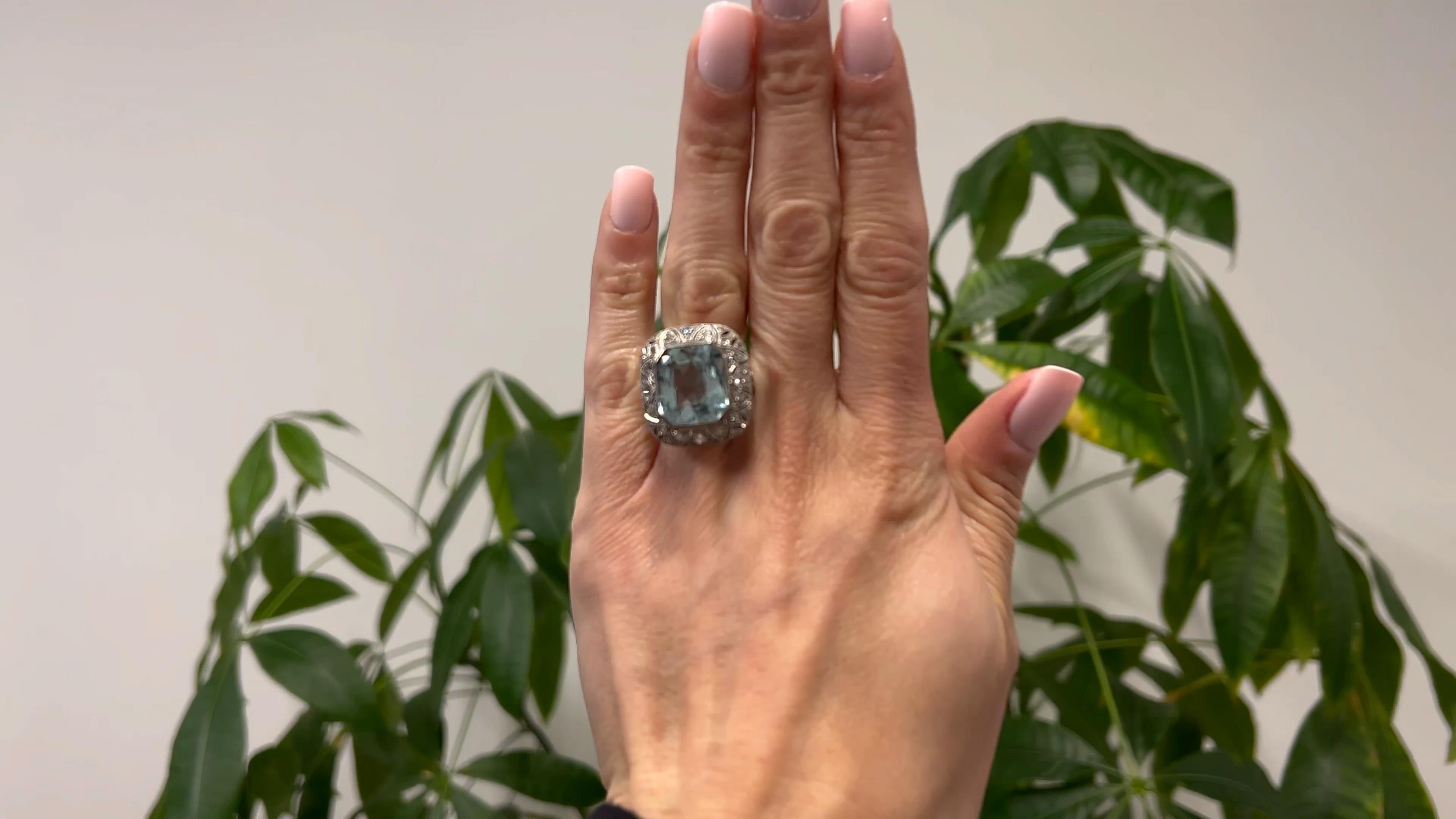 One Art Deco Aquamarine and Diamond 18k White Gold Filigree Cocktail Ring. Featuring one octagonal brilliant cut aquamarine weighing approximately 13.00 carats. Accented by 24 old European and old mine cut diamonds with a total weight of