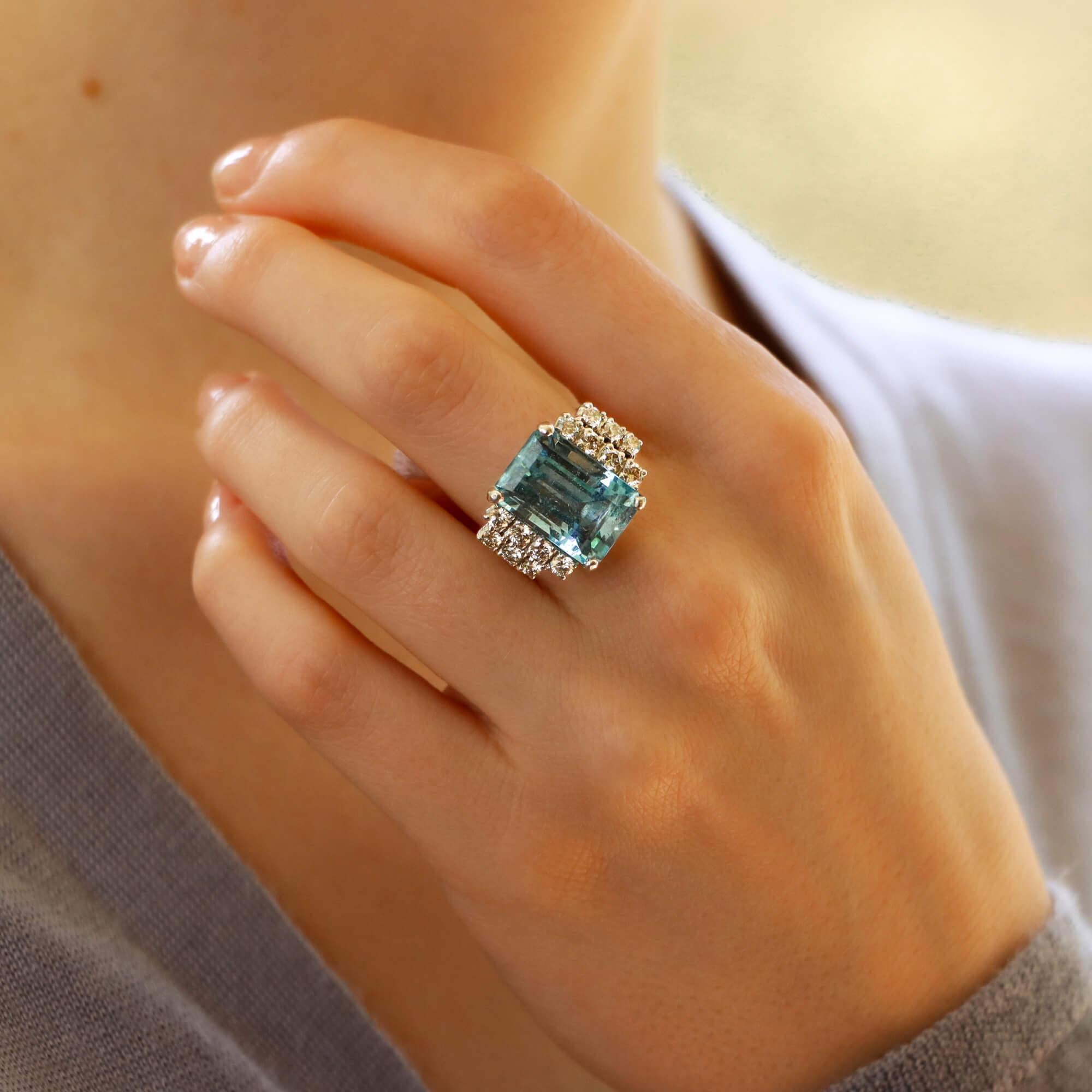 A striking Art Deco aquamarine and diamond cocktail ring set in 18k white gold.

This beautiful piece is predominantly set with a sky blue colored emerald cut aquamarine which is four claw set to center. To each side of the aquamarine there are two