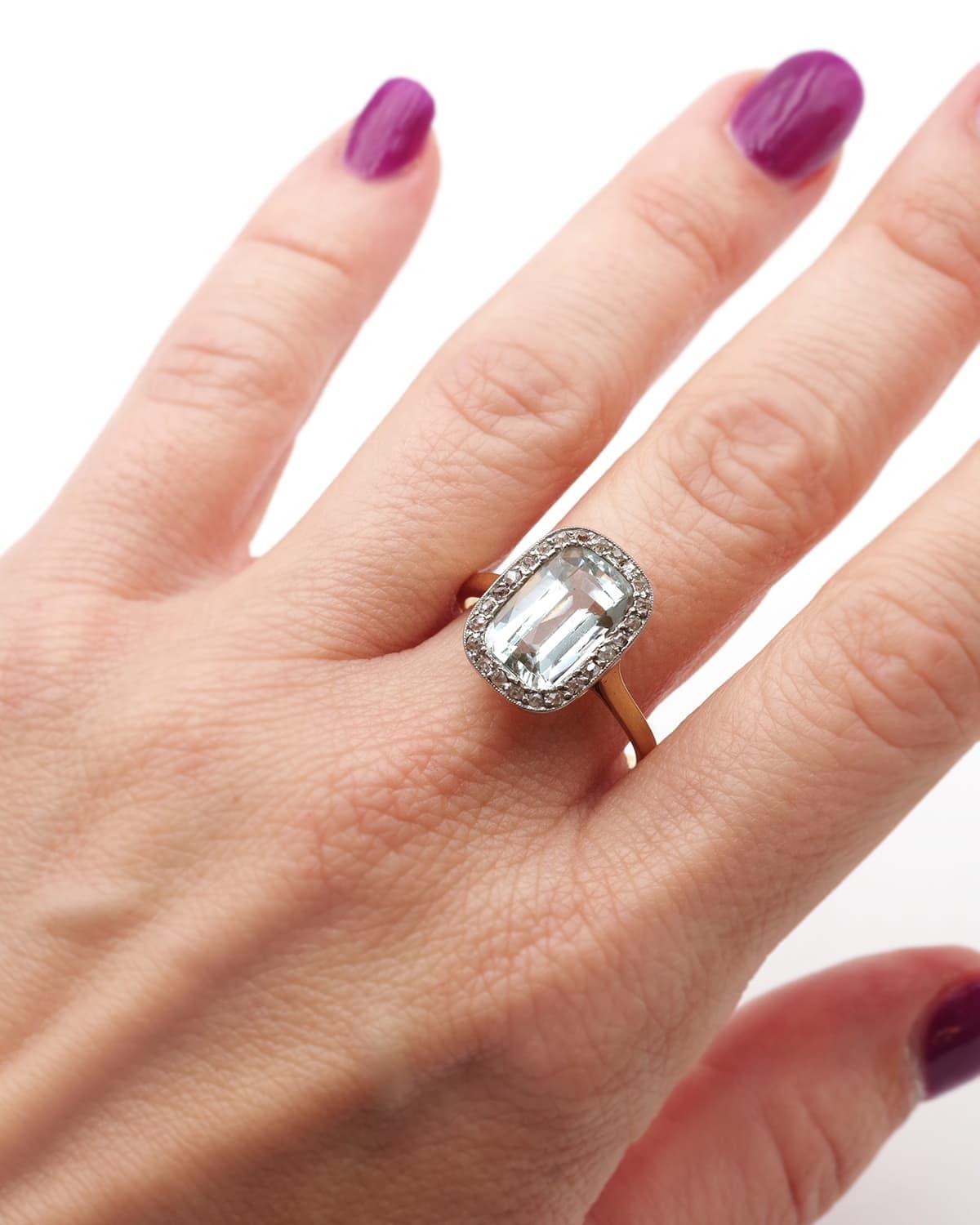 Art-Deco-Ring mit Aquamarin und Diamant aus 18 Karat Gold und Platin. Antiker Ring mit einem rechteckigen Aquamarin im Kissenschliff in einem eisblauen Farbton. Er ist von Diamanten im Rosenschliff umgeben. Der Aquamarin von etwa 3,33 Karat ist in