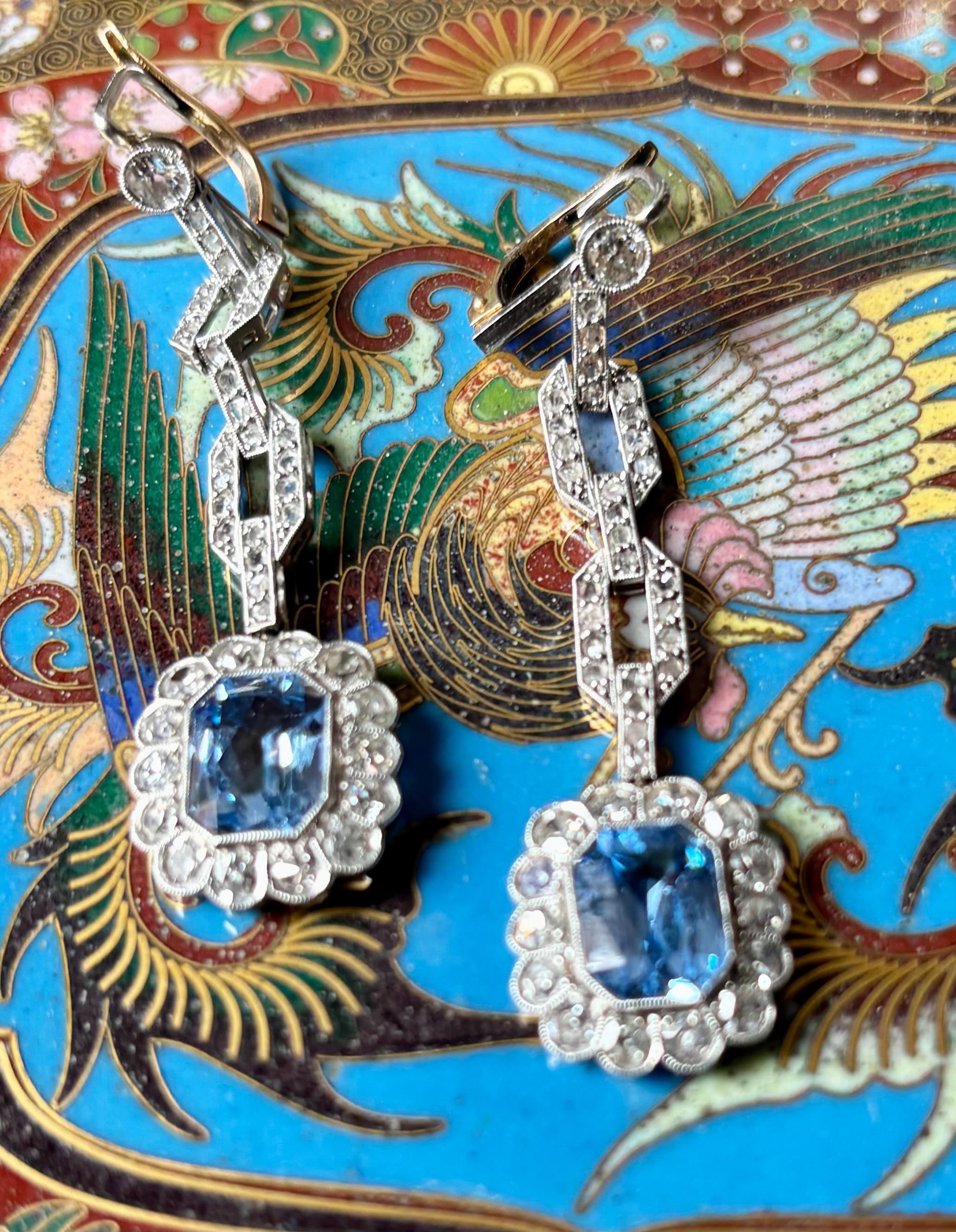Pendente Art Deco con acquamarina e diamanti  Orecchini anni '20.
Questi squisiti orecchini a pendente risalgono all'epoca dell'Art Deco, intorno agli anni '20. Ogni orecchino è caratterizzato da un'acquamarina vibrante dal taglio smeraldo,